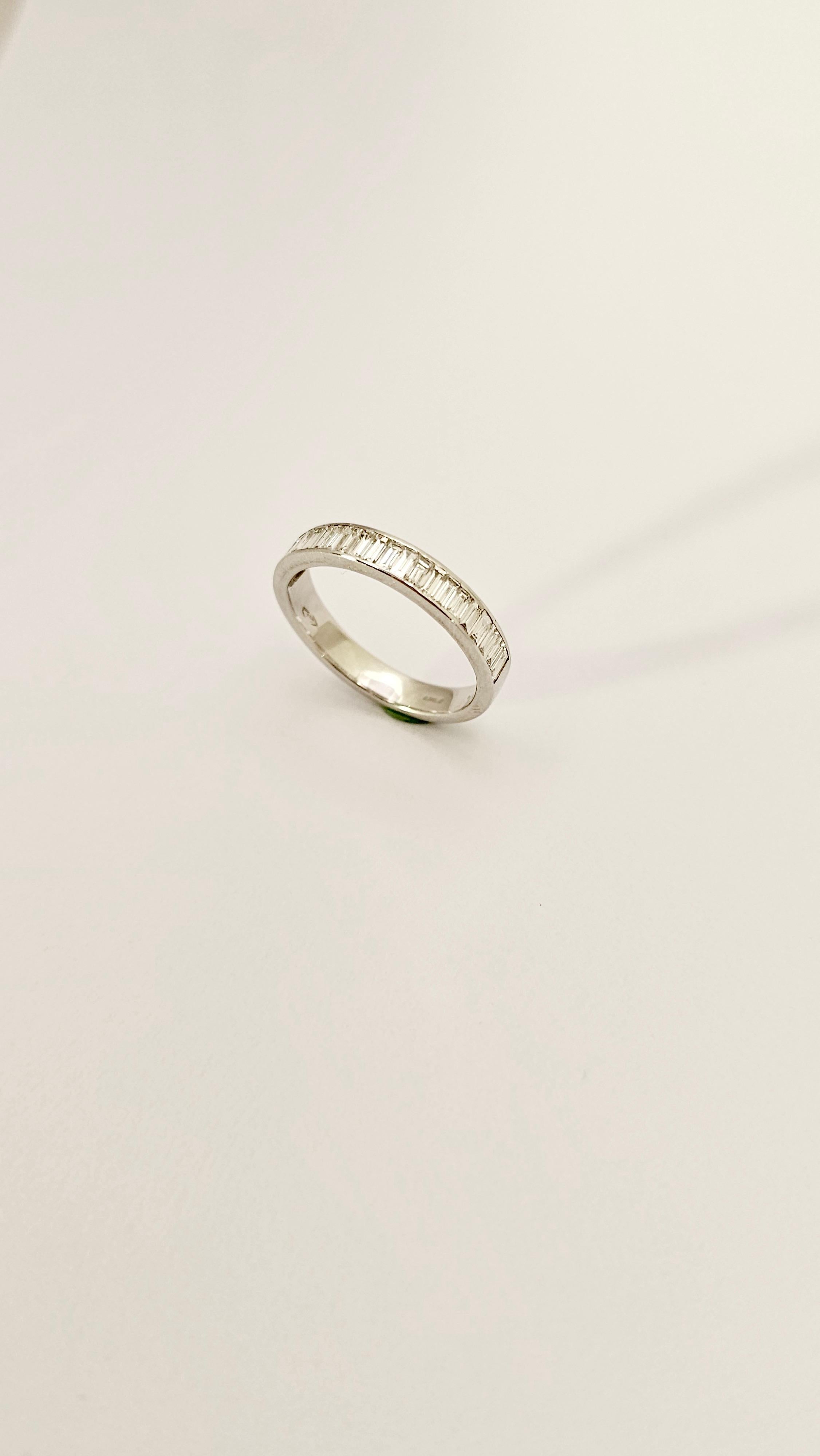 A bandage design with modern and contemporary lines.
This ring is made of 18 kt gold ( the weight is 3.50 grams ) full.
Set inside the band, which is 39 mm high, are 22 baguette-cut Diamonds, F color, VVS clarity and weighing 0.88 carats.
The size