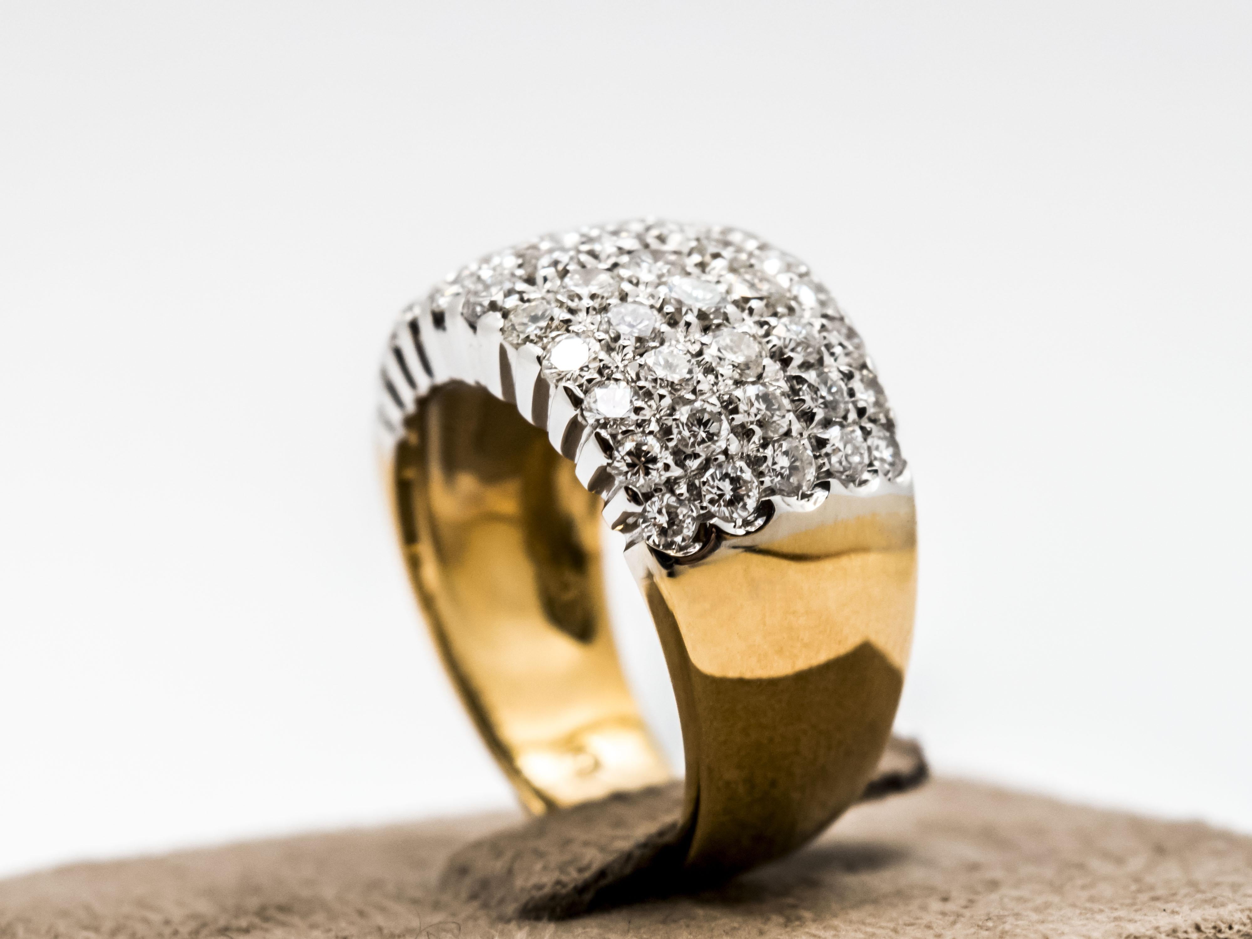 Un classico anello a fascia creato in oro 18 Kt, massiccio, dal peso di gr 8.65.
La fascia è in due colori di oro. La parte che supporta i diamanti è in oro bianco 18 Kt mentre la parte della fascia è in oro giallo 18 kt.
Questo dettaglio bicolore