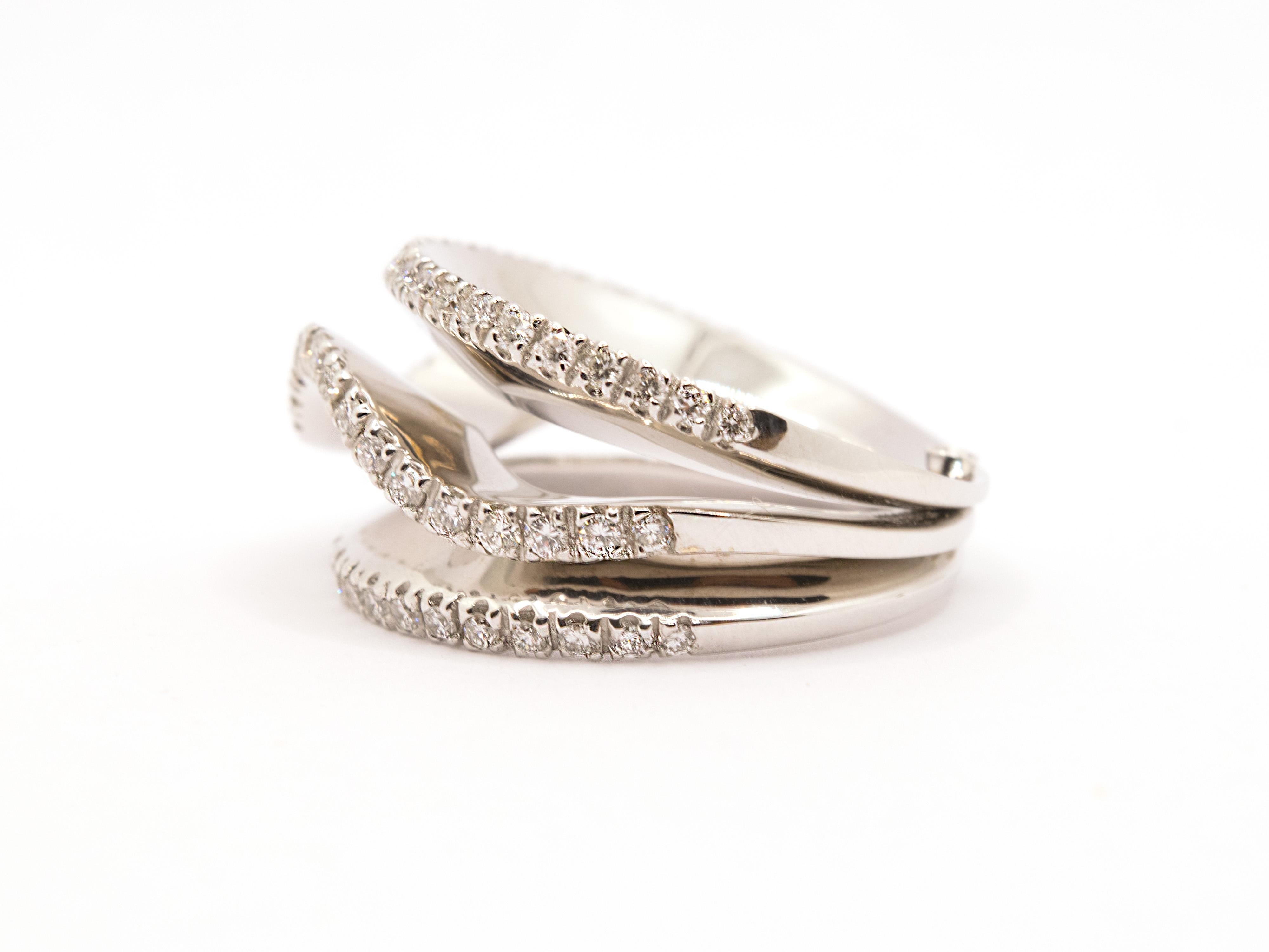 Un elegante anello a fascia in oro bianco massiccio 18Kt dal peso complessivo di gr. 18,10.
Questo anello è formato da tre anelli a fedina, due lineari e uno ondulato, uniti da un perno in oro situato nella parte posteriore del gambo.
Questo