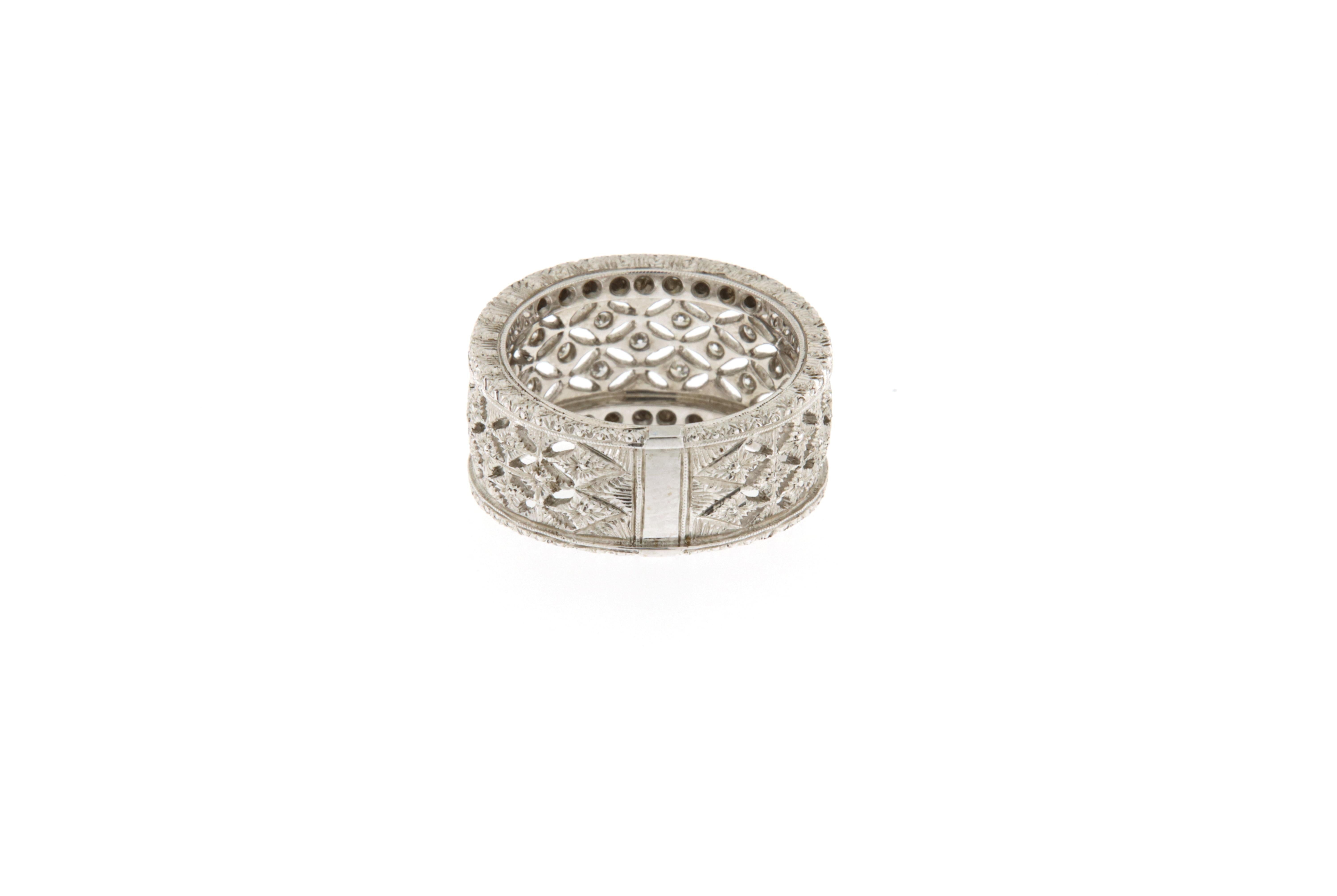 Questo anello a fascia in oro bianco 18 kt. si ispira nel design ai modelli di Buccellati. E' interamente lavorato a mano con un decoro traforato e incassato con brillanti (ct.0.38) su tutta la fascia, tranne che nella parte inferiore dell'anello,