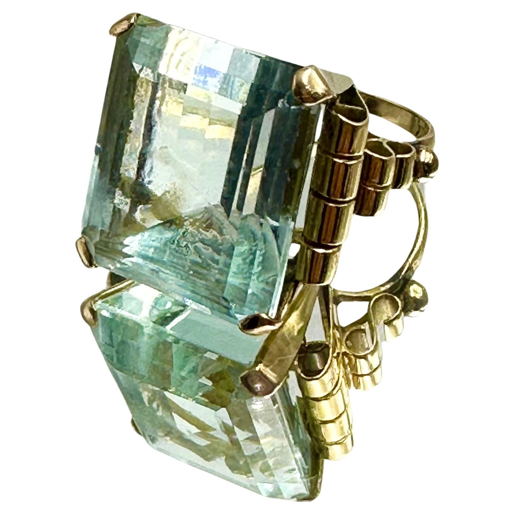 Grande anello con acquamarina (35 ct.), taglio smeraldo, di colore azzurro intenso.
Raffinata montatura in oro rosa 18 carati, in stile art decò.
Prodotto artigianalmente in Italia, 1940 circa.

