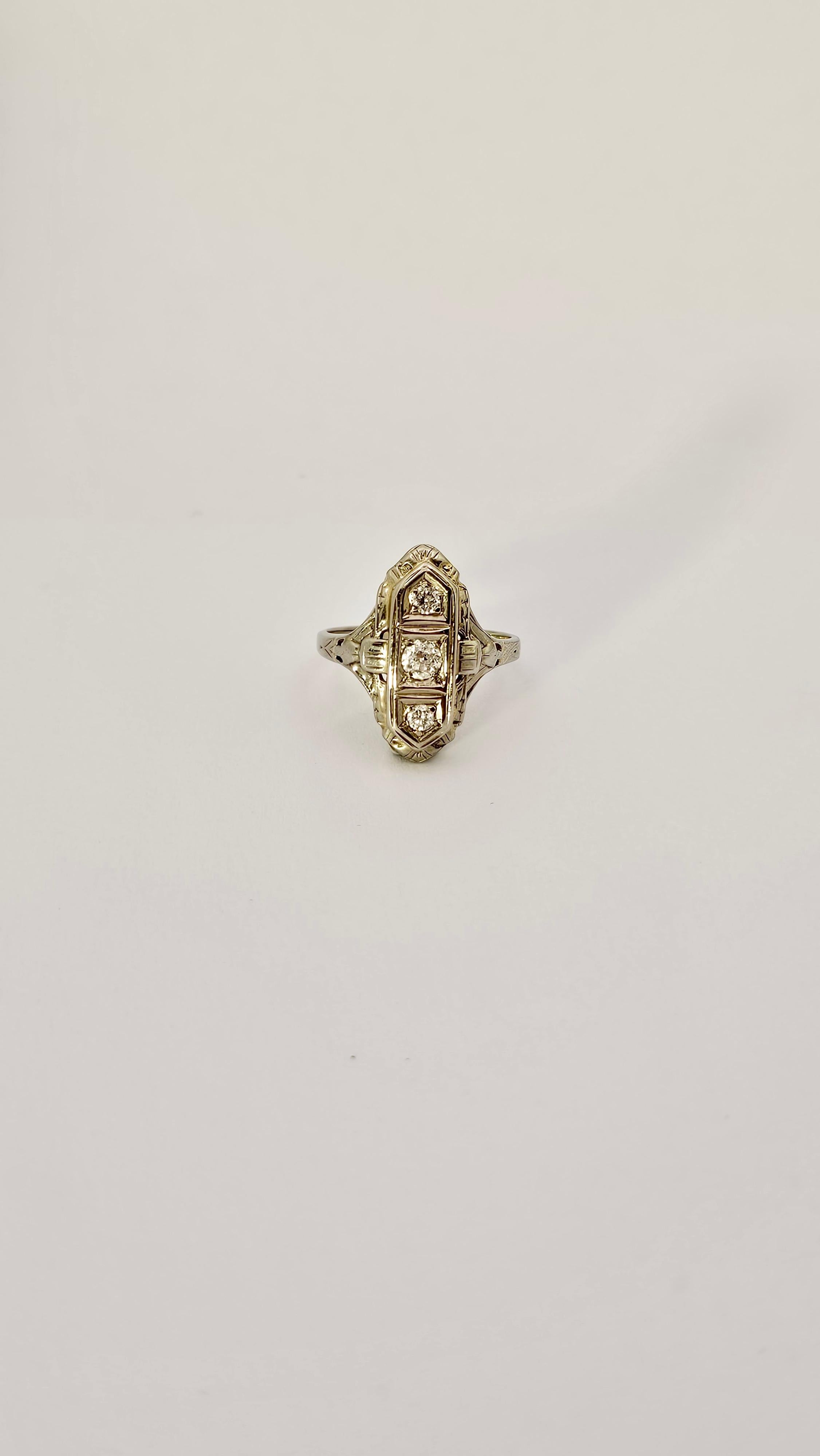 A stunning Art Deco design ring in 18kt white gold and brilliant-cut Diamonds.
This ring has an ogive shape and is embellished with three brilliant-cut Diamonds set vertically at the top.
The central Diamond has a larger size than the other two.
The