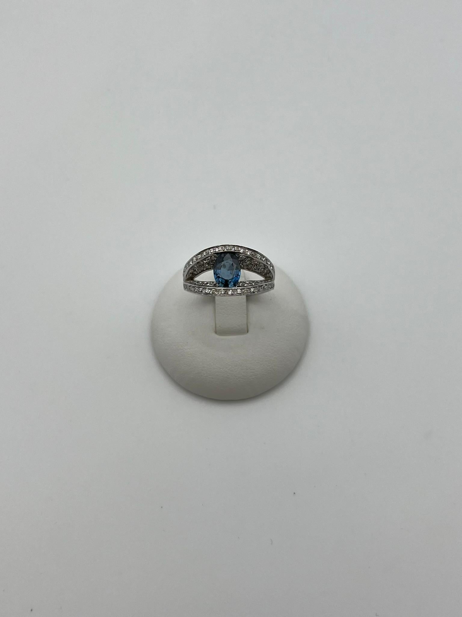 Élégante bague fabriquée à la main en Italie en or blanc 18 carats 750/00. Le design est unique, la forme rappelle un œil ouvert, la pupille est un saphir bleu naturel pesant 0,60 ct, tandis que les paupières sont serties de diamants naturels de