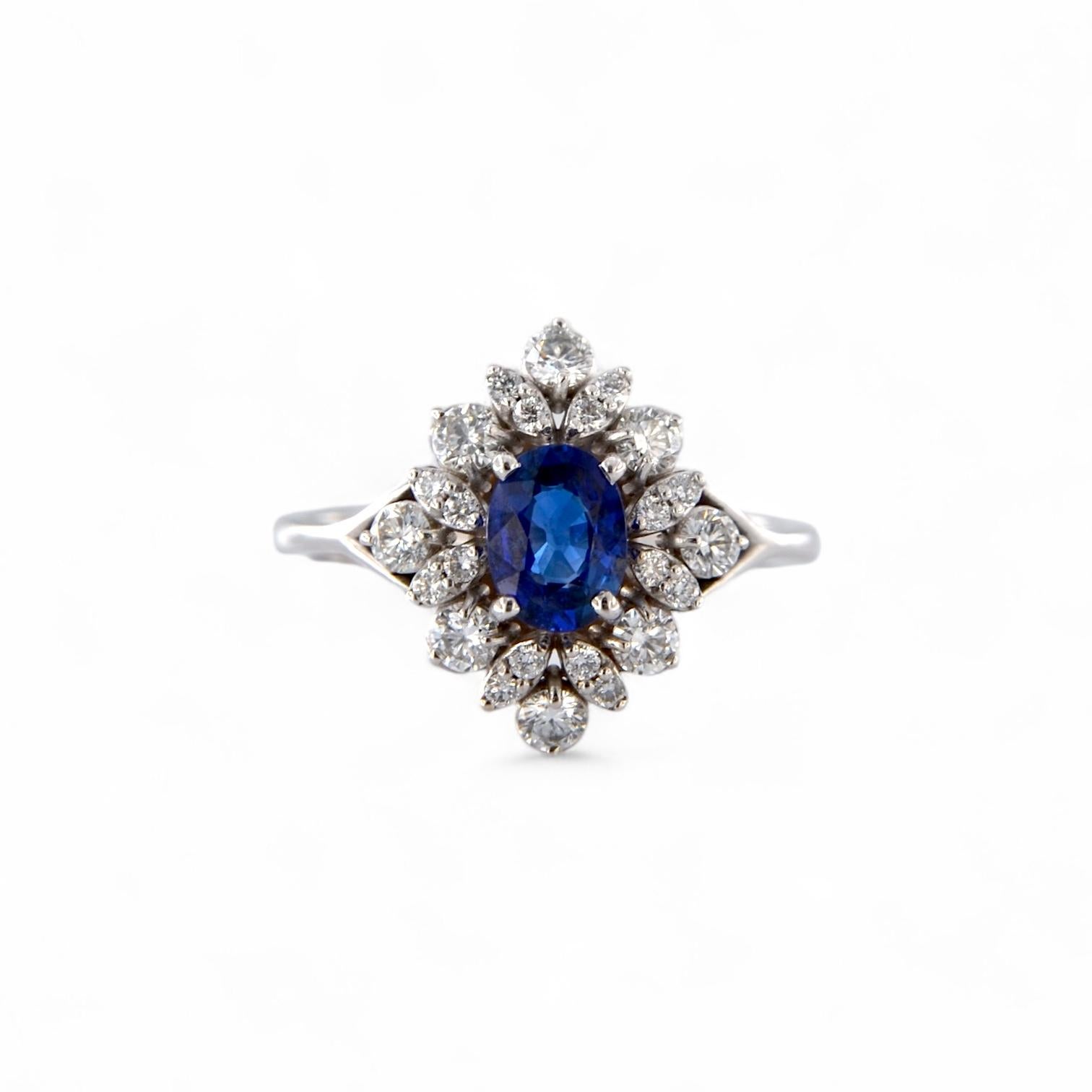 Cette bague exquise est un hommage à l'élégance intemporelle. Fabriquée à la main en or blanc 18 carats, elle est ornée d'un splendide saphir naturel de 0,81 carat de taille ovale, à la couleur profonde et intense. La pierre centrale est encadrée