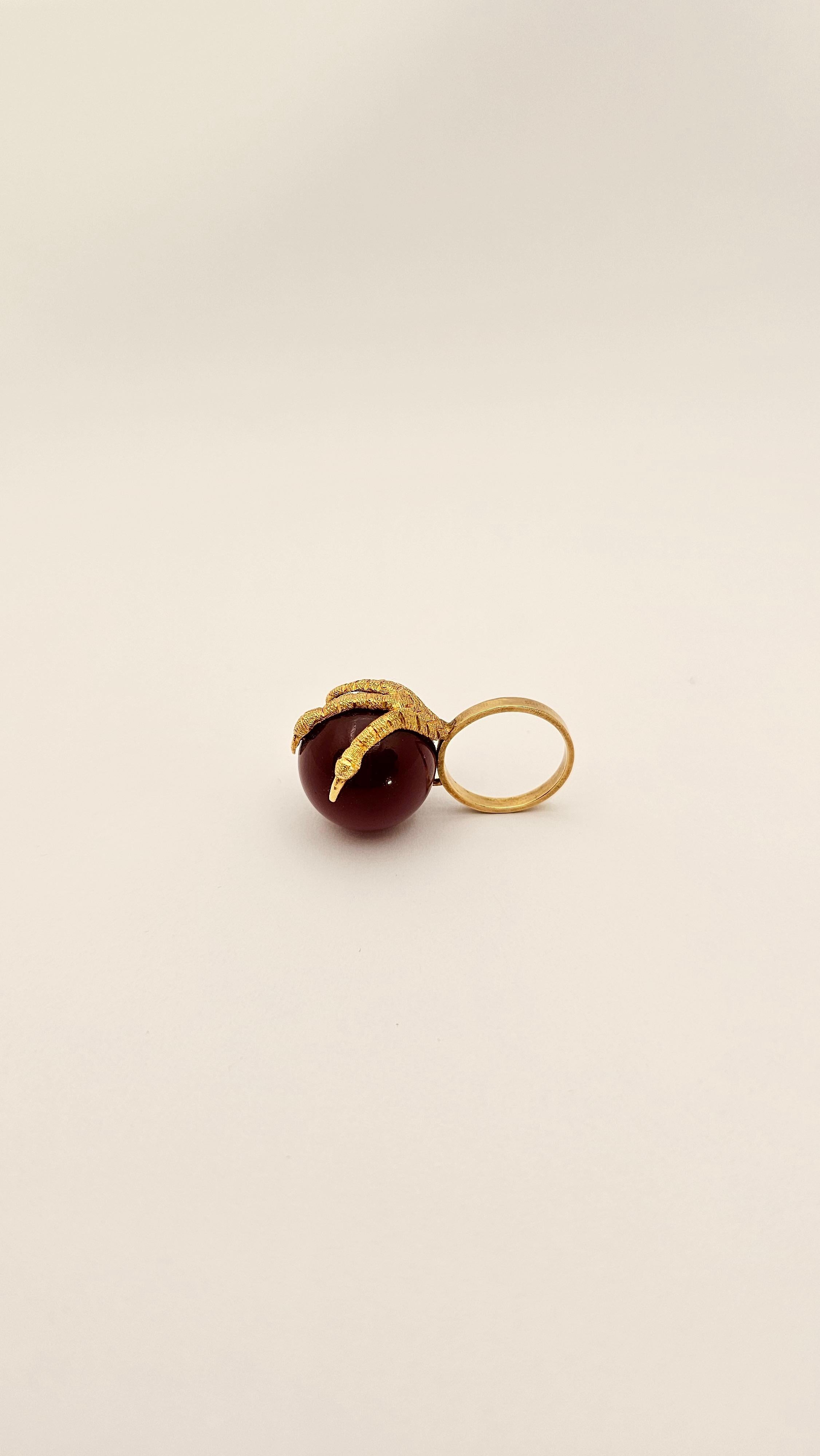 An incisive and eye-catching ring design from the 1950s era.
Made of 18 kt yellow gold and dark red Jasper sphere. The claw part is completely made and finished by hand.
Carnelian has a diameter of 19 mm, its height is 40 mm ( measured from the band