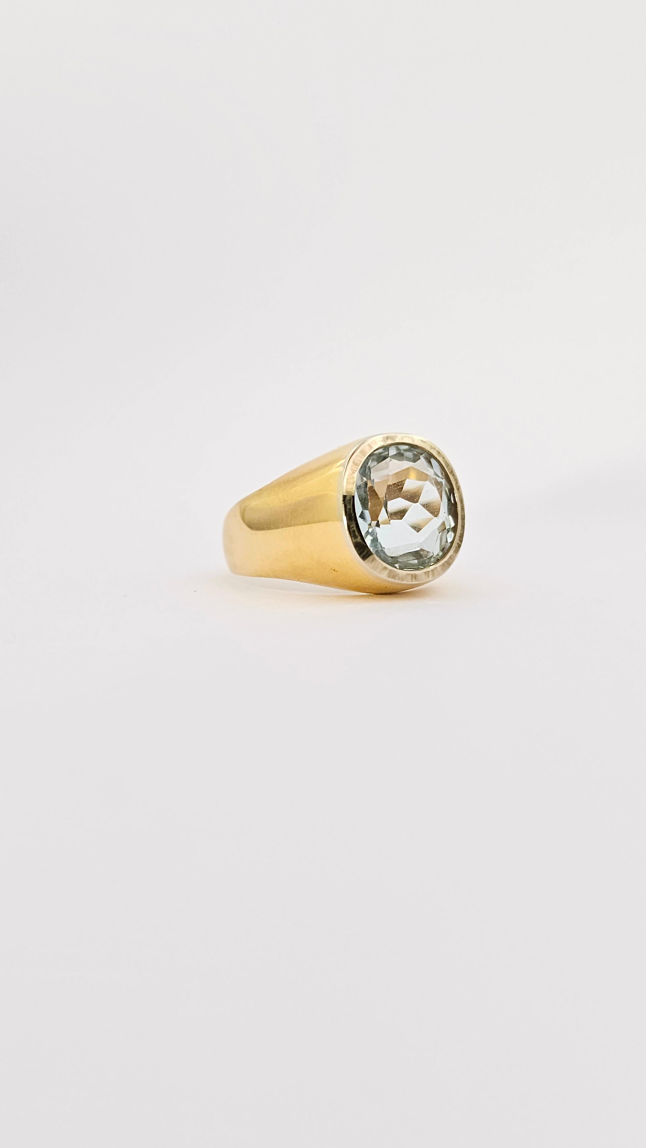 Un anello chevalier in oro giallo, massiccio, 18 Kt di epoca 1970 realizzato a mano.
Impreziosito da una Acquamarina di taglio ovale sfaccettato e dal colore azzurro chiaro. La misura della pietra è di 11x10 mm.
Il contorno della pietra nella parte