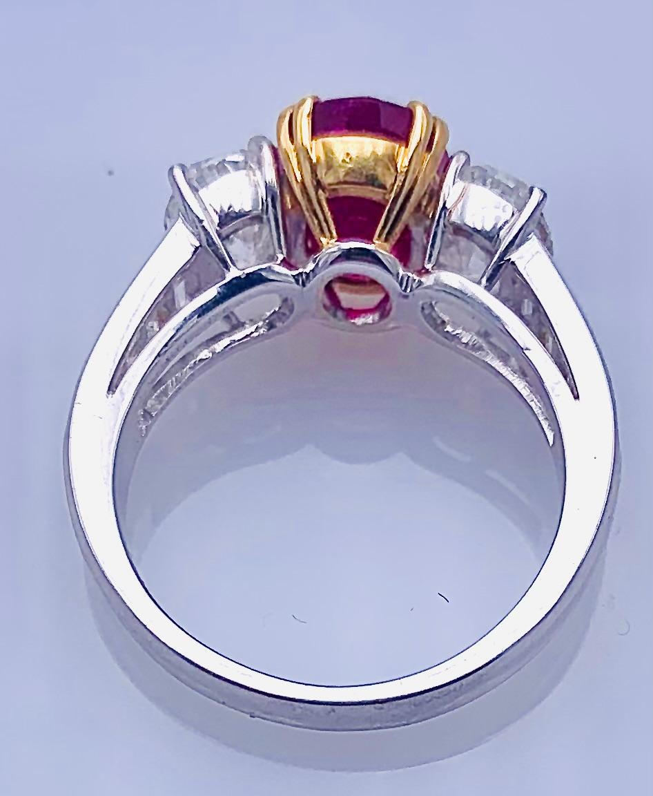 Italian manufacture ring in white gold and central yellow gold bezel with Natural Ruby Origin Burma  of ct 3.59 certified by Gubelin , two oval-cut diamonds of about ct 0.75 each color F/G clarity VS
and small baguettes on the stem for about ct 0.20