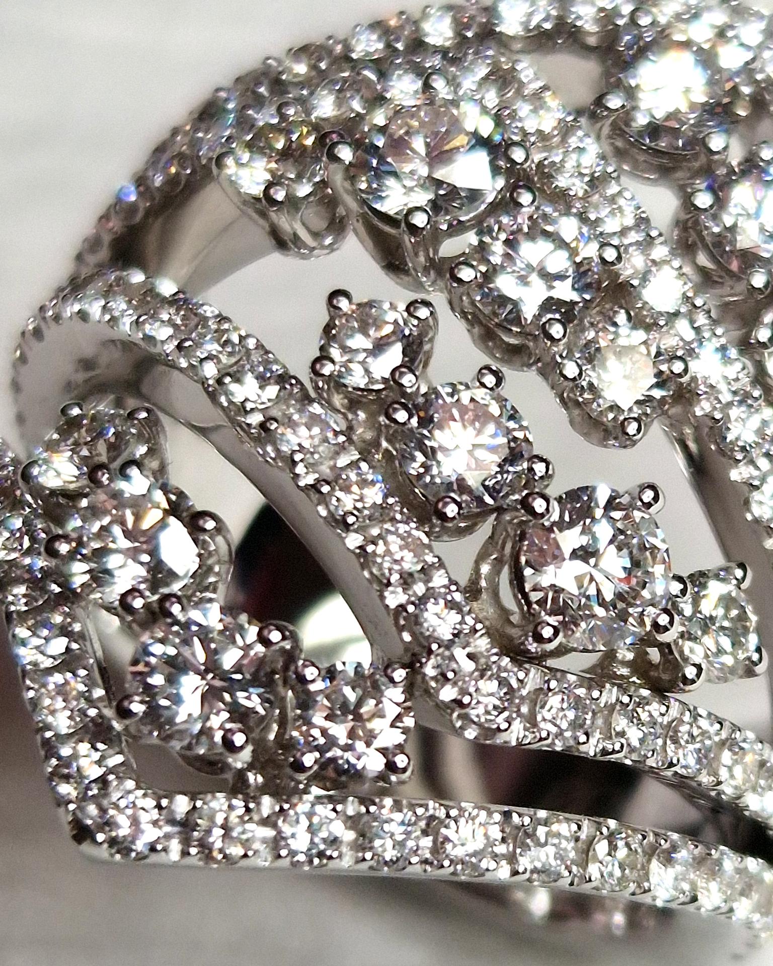 Questo anello da cocktail realizzato in oro bianco 18kt fa parte della collezione PARENTESI. Il nome è dato dalla forma geometrica delle quattro volute del gambo che lo costituiscono. Questo motivo crea un volume a fascia che veste in maniera molto