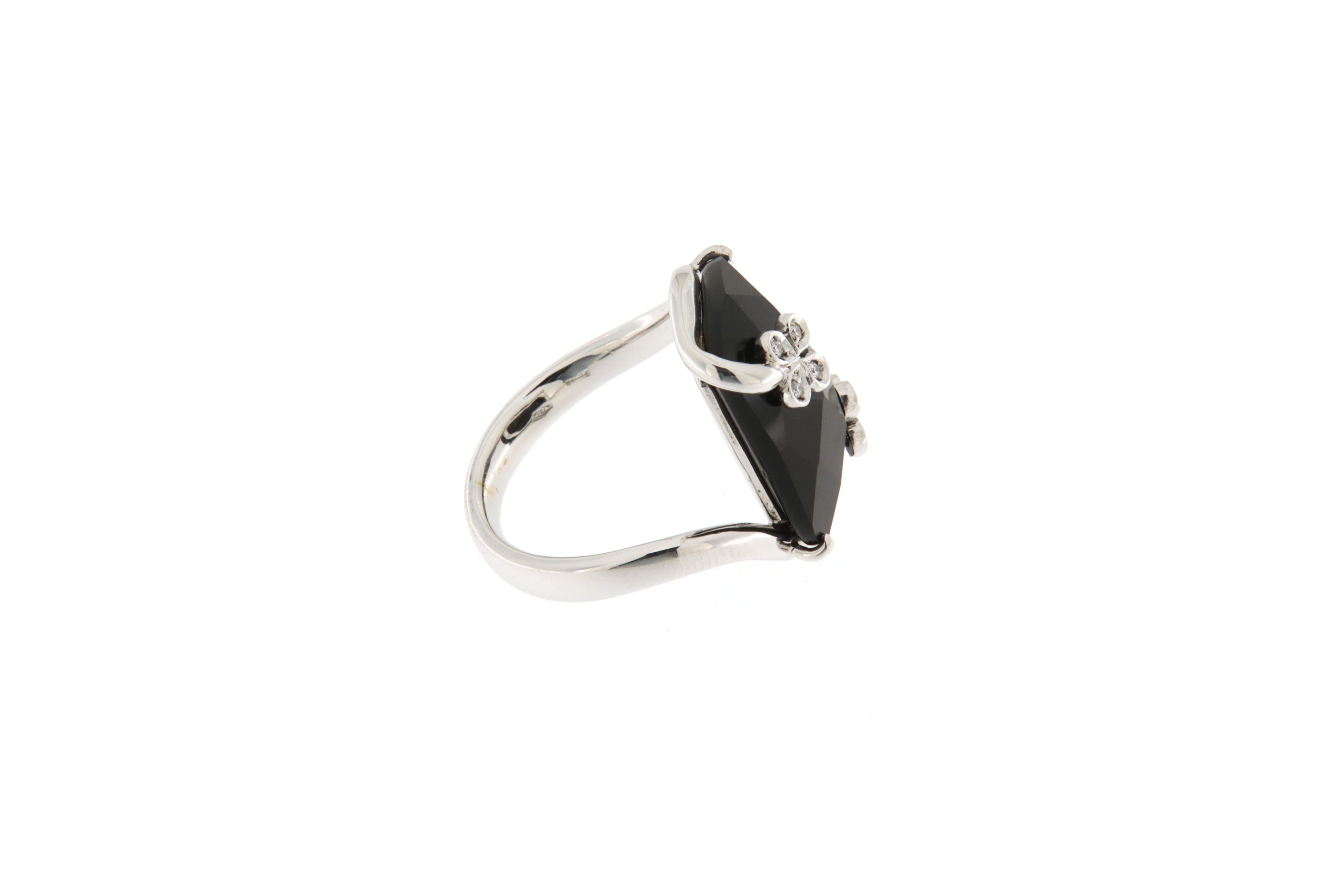 This ring was handmade by Italian goldsmiths by mounting a rectangular onyx element as the centerpiece, faceted at the top. The design of the ring hugs the shape of the finger, creating two small shamrocks with diamonds that embellish the onyx,