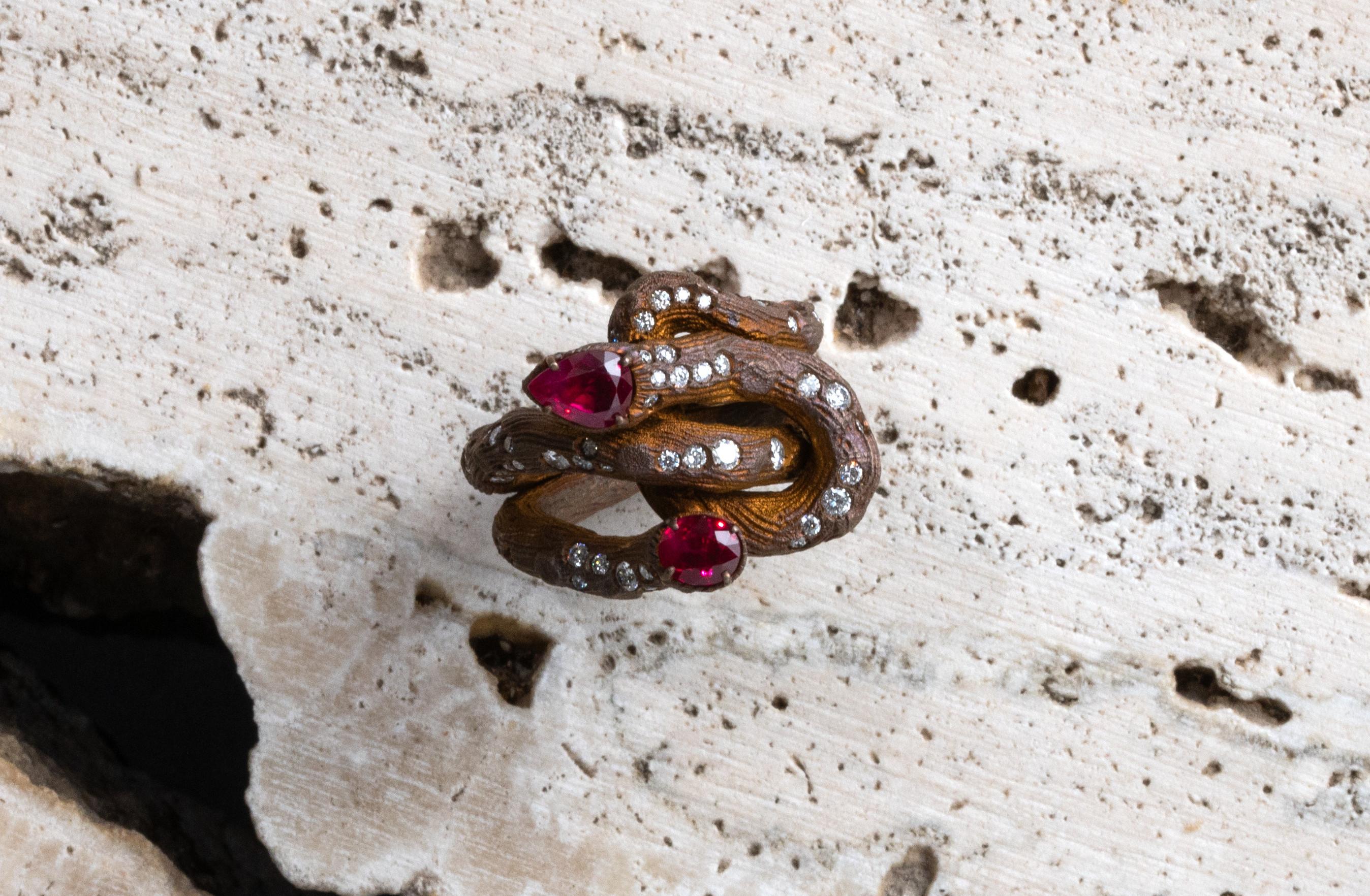 Anello realizzato in titanio anodizzato, impreziosito da piccoli diamanti rotondi taglio brillante peso carati 1,23, rubino a goccia carati 1,06 e un rubino ovale carati 0,88.
It is a unique piece. 

La leggerezza del materiale rende molto