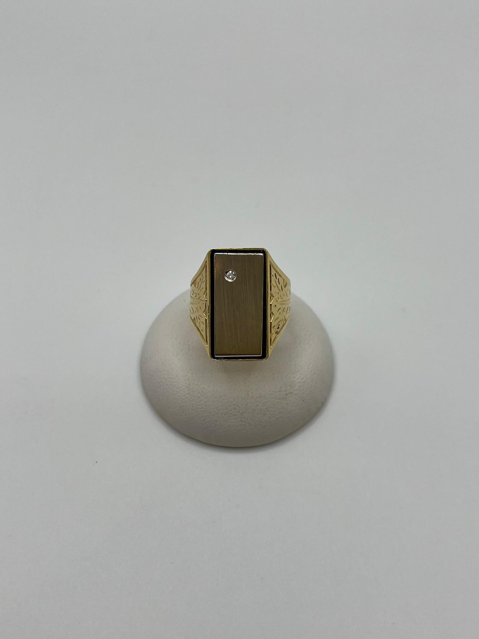 Bague raffinée pour homme fabriquée à la main en Italie en or jaune 18 carats. Les épaules de la bague sont ciselées de motifs décoratifs qui rendent le bijou unique. La lunette présente une plaque polie en or blanc 18 carats, encadrée par de fines