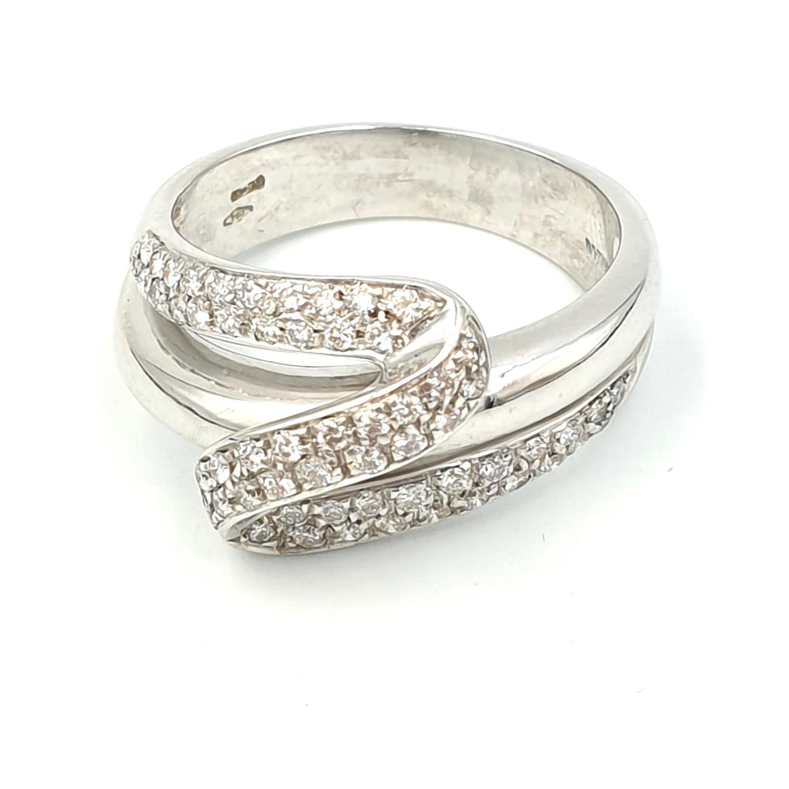 Damiani double crossband ring in solid 18-karat white gold, paved with 60 natural one-point F-color diamonds and minimum grade VVS1. 

Dimensions of the ring head 3 x 1.2 x 0.6 centimeters. Weight 6.6 grams.

Italian size 14, US size 6.75. We can