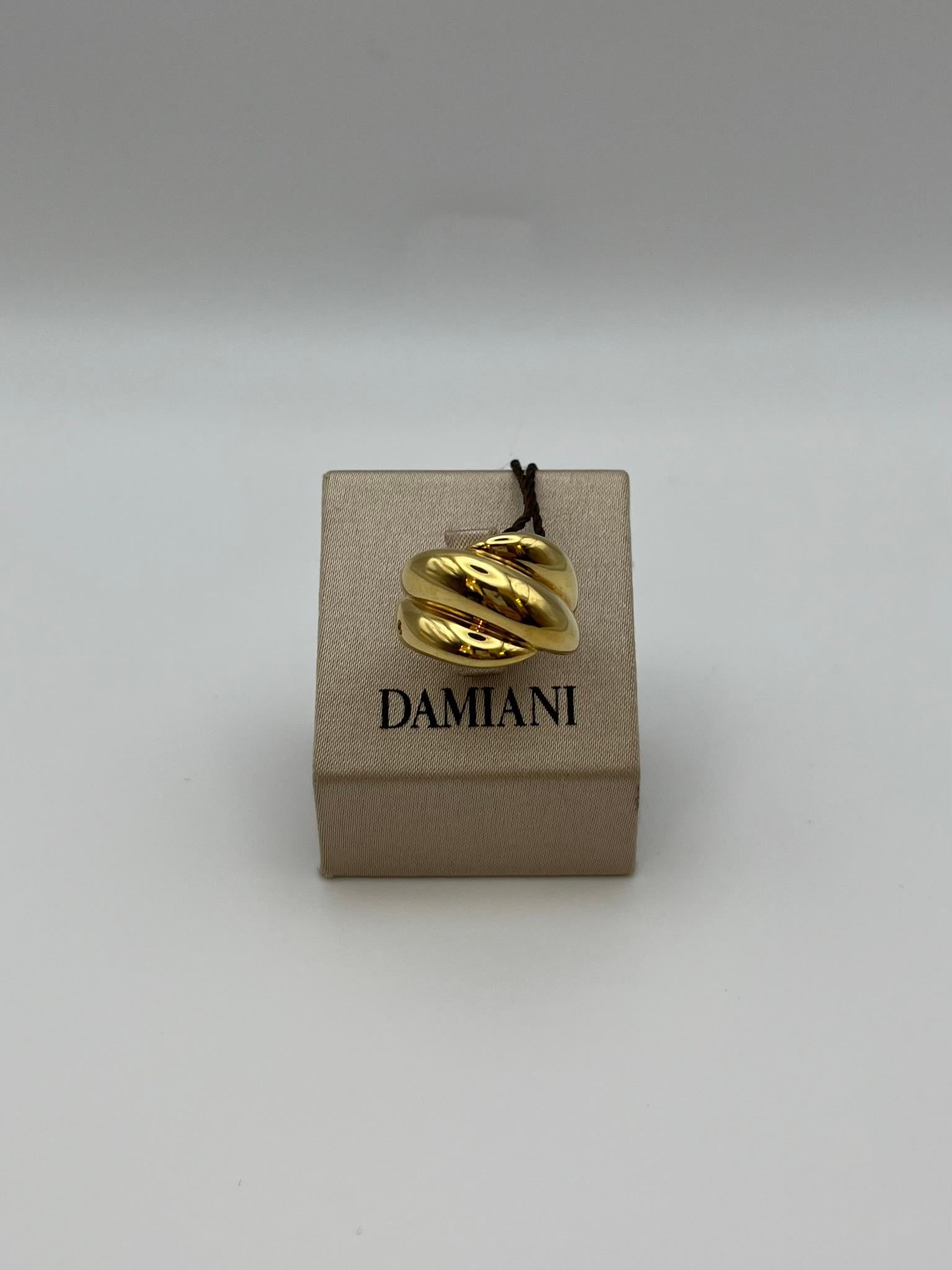Bague Damiani de la collection Gomitolo en or jaune 18 carats, avec un large anneau et un diamant taille brillant de 0,01 ct. Fabriquée en Italie, cette pièce emblématique conçue dans les années 1980 exprime une élégance et un savoir-faire fluides :