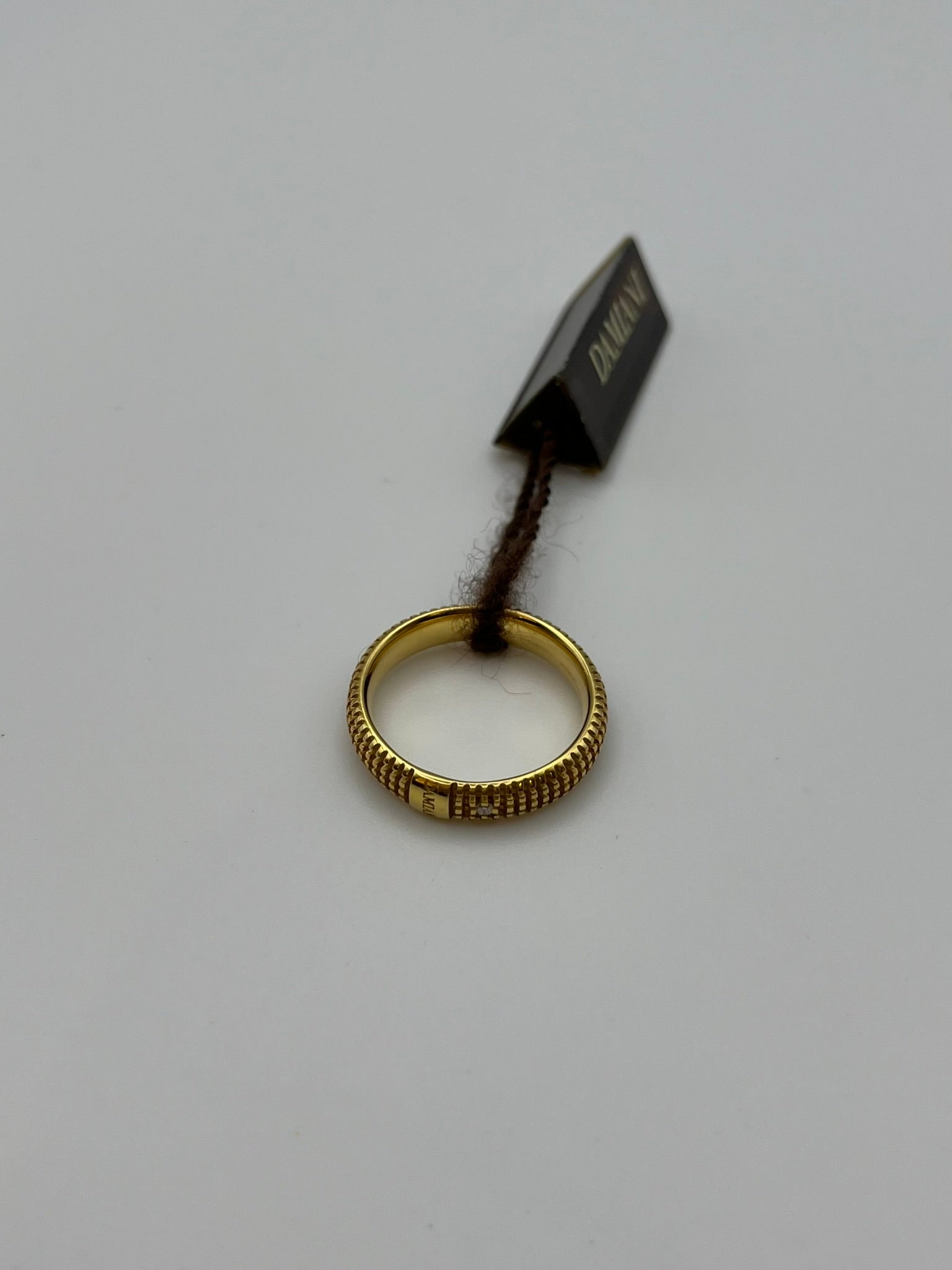 der Damiani-Ring aus der Kollektion Metropolitan Dream ist aus 18 Karat Gelbgold gefertigt. Er hat ein modernes und raffiniertes Design, das mit Reliefs und einem natürlichen Diamanten im Brillantschliff von 0,01 ct. verziert ist. Sie ist ein Symbol