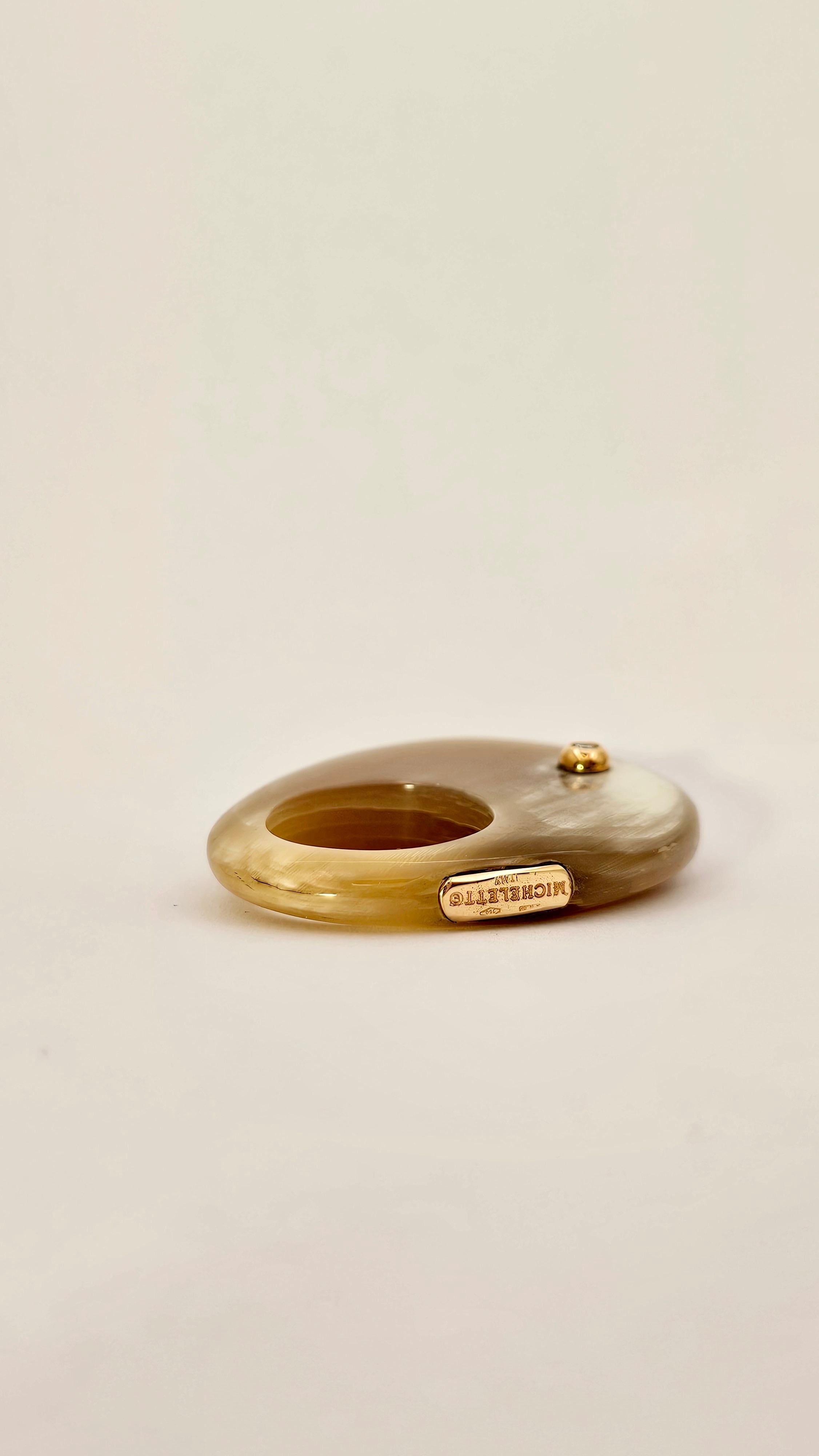 A modern and unique ring design characterized by a rounded and original shape.
This ring is made of Galalite, a plastic material similar to Bakelite.
Embellishing this jewel is a brilliant-cut White Diamond weighing 0.08 carats.
There is also, at