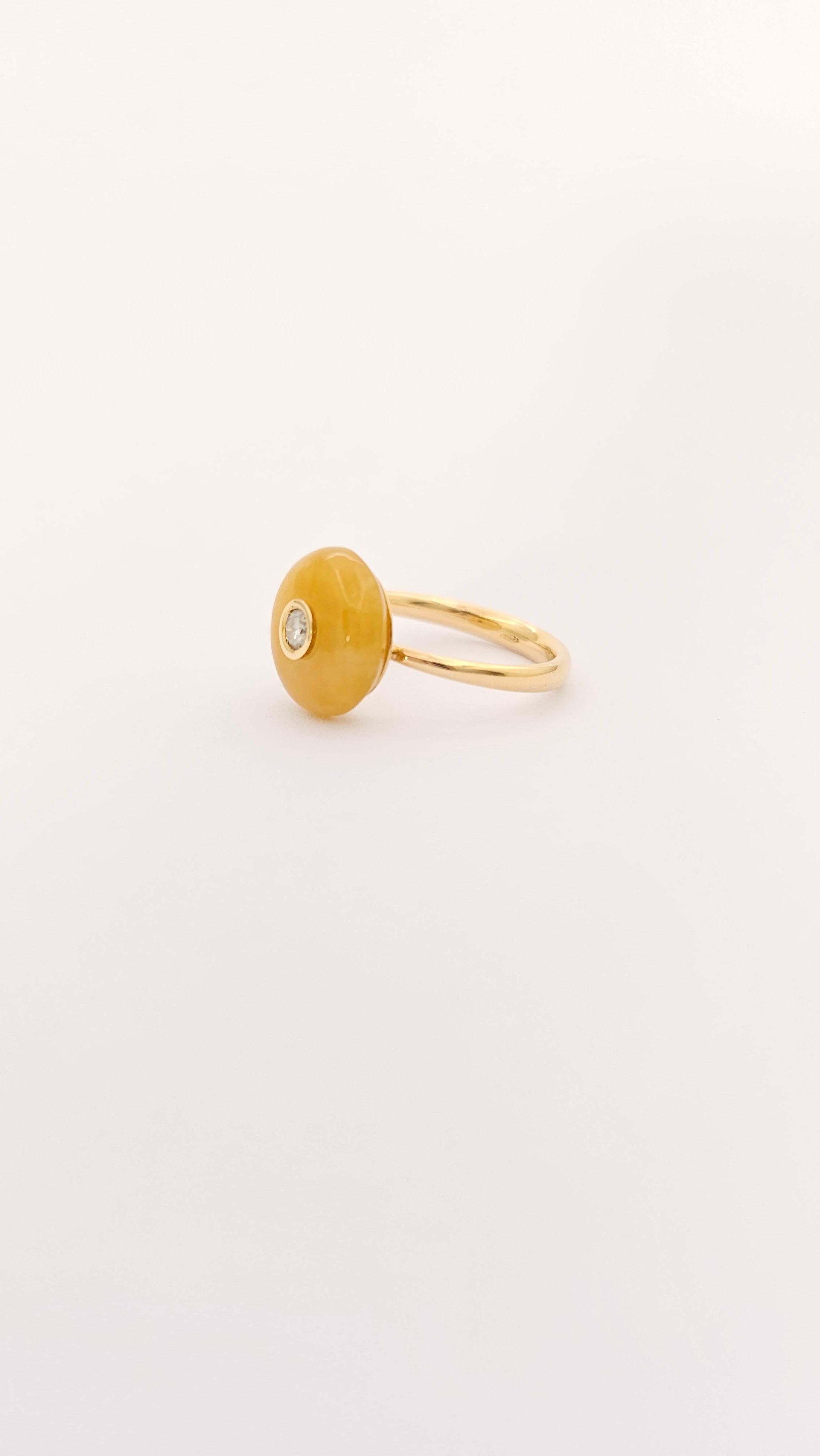 Un delizioso anello realizzato in oro giallo 18Kt. La parte superiore di questo anello è composta da una Giada di colore giallo scuro, intenso, tagliata a cabochon rotondo. Il diametro della Giada è di 12 mm. Al centro della pietra vi è incastonato