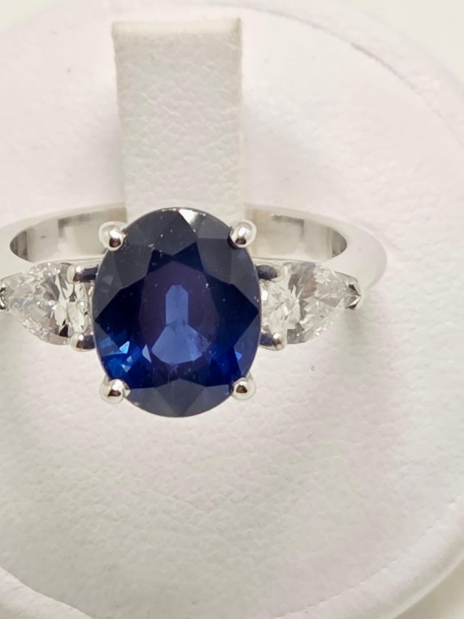 Elegante anello in oro bianco 18 kt, impreziosito da un raffinato zaffiro blu  da 3,80 carati, protagonista assoluto per intensità cromatica e brillantezza. La pietra centrale è armoniosamente incorniciata da diamanti taglio goccia per un totale di