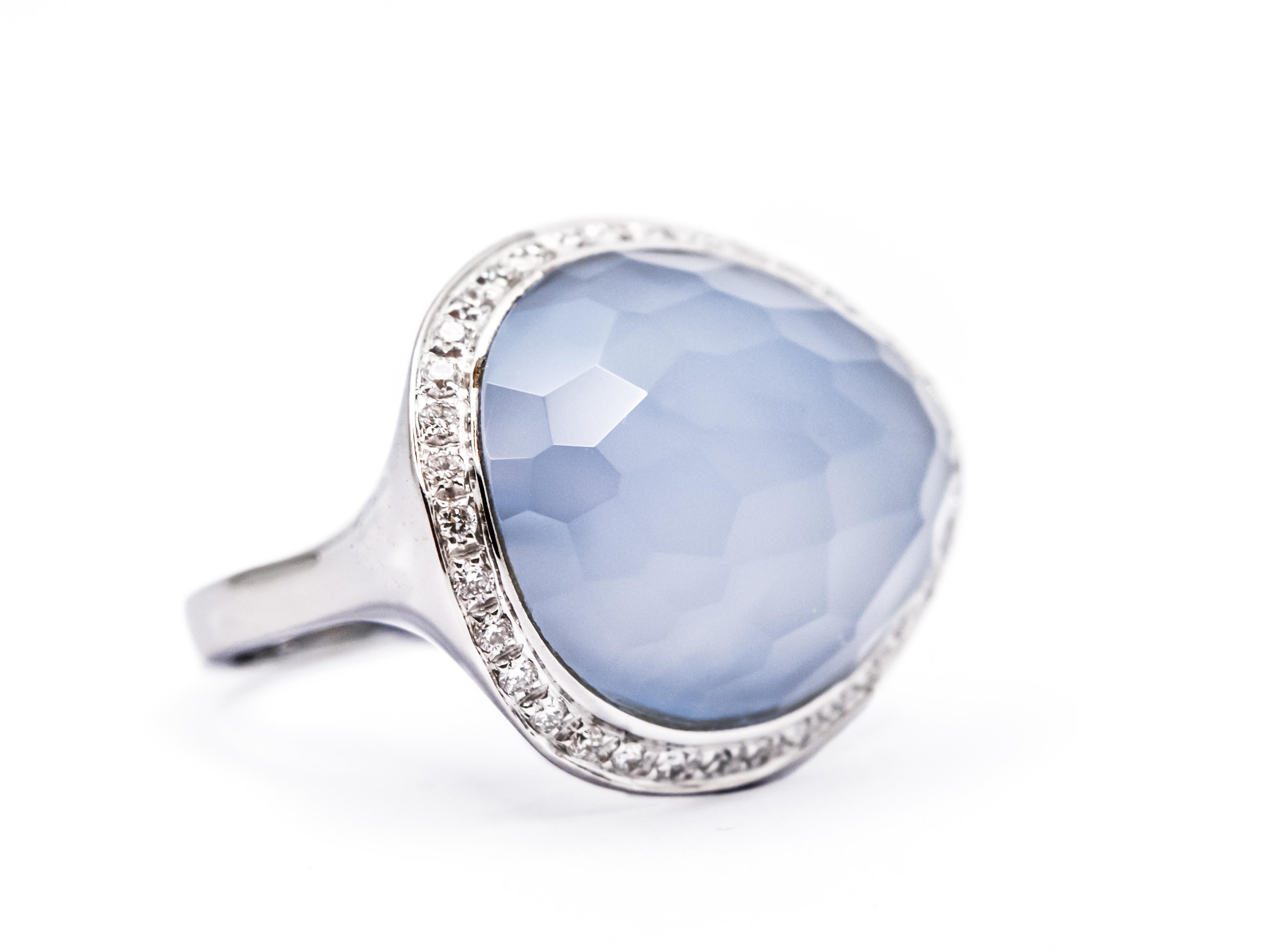 A beautiful ring with an imposting size. The top measures approximately 2cm x 2.4cm.
This ring is constructed of 18 kt white gold with a total weight of 13.15 grams. The chalcedony has a domed shape and a briolet cut and is surrounded by a frame of