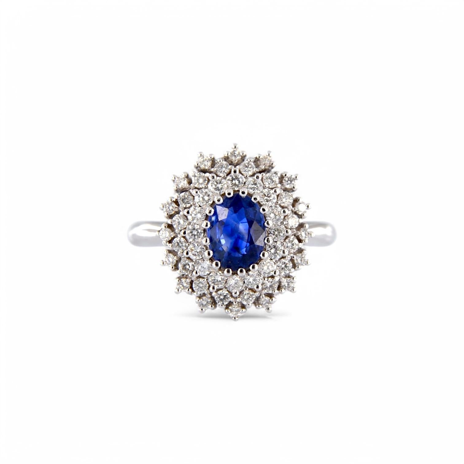 Réalisée en or blanc 18 carats, cette magnifique bague contemporaine incarne l'élégance et la sophistication. Au centre de la composition, un saphir naturel de 1,28 carat, de taille ovale, brille d'un bleu intense et lumineux. La pierre centrale est