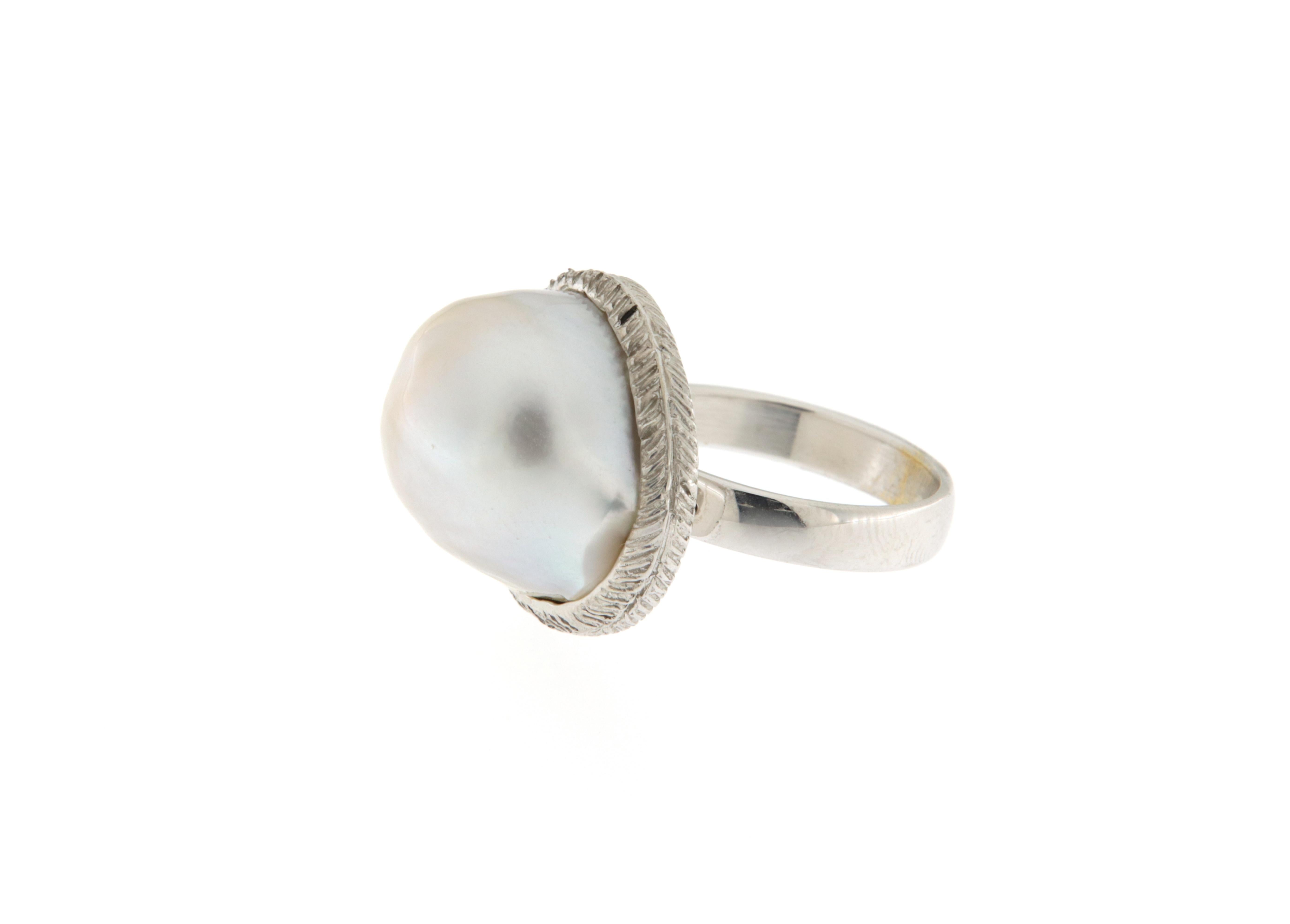 Este anello en oro blanco nace de la forma particular de la perla australiana, sobre la que se ha proyectado y realizado el anello, precisamente para realzar la belleza natural de la perla.