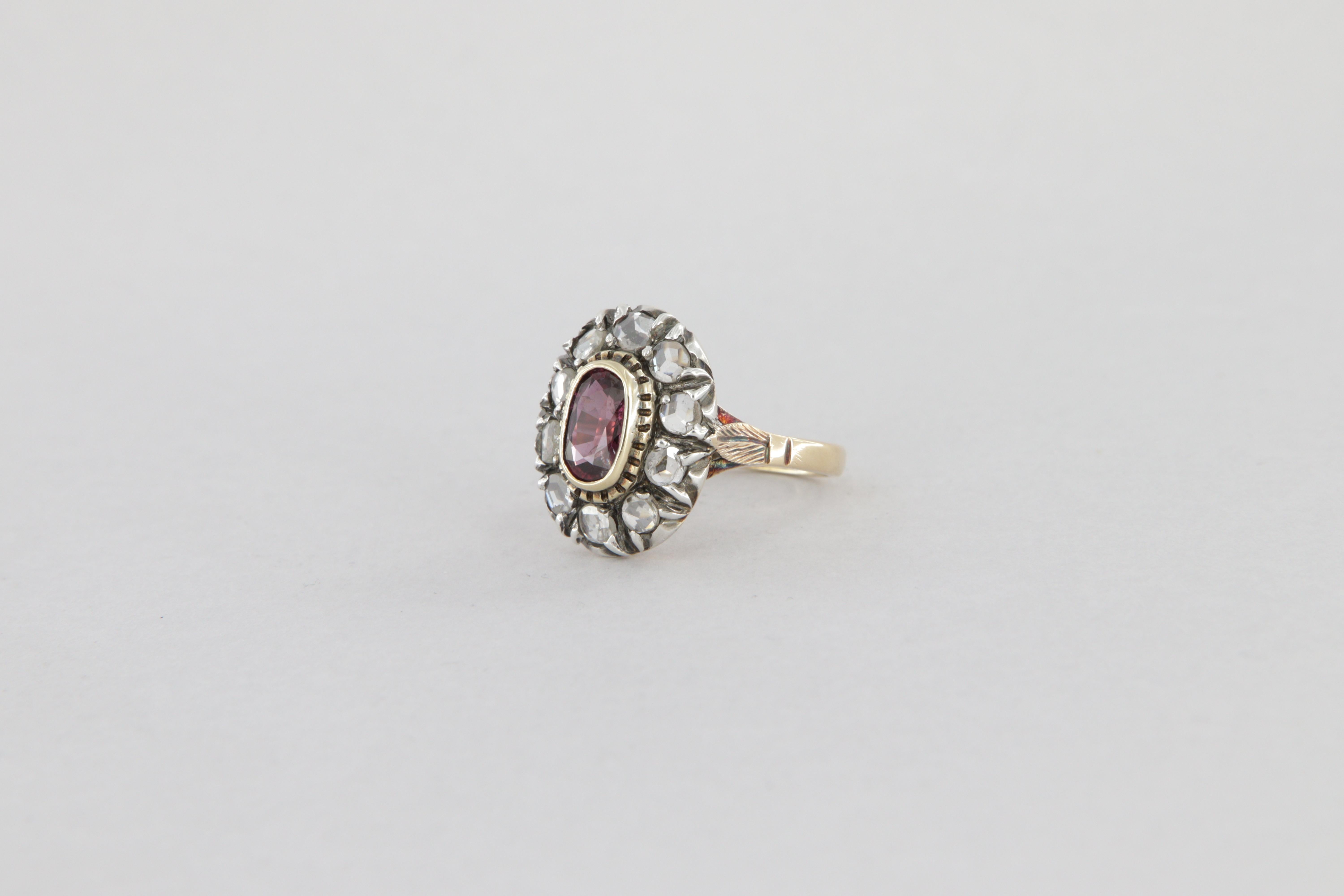 Bague de style antique en or et argent avec diamants et un rubis ovale ct 0.95

Cette bague de style antique est en or 18 carats et en argent 925. Au centre se trouve un rubis de forme ovale entouré de 10 diamants taillés en rose. La tête de