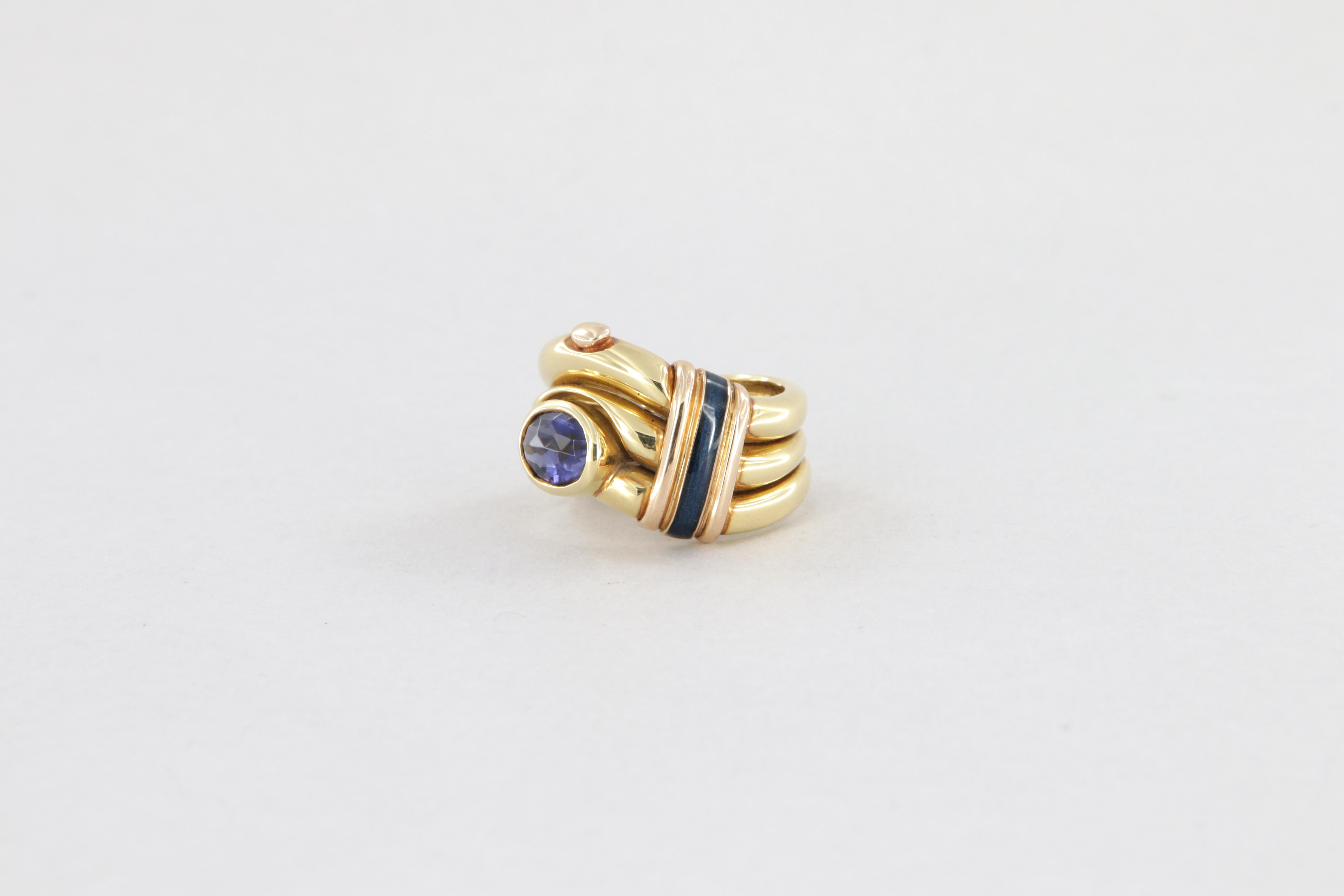 Anello La Nouvelle Bague in oro, smalto a fuoco e iolite ovale.

Anello a fascia in oro giallo 18kt, peso g 13,4, con dettagli in oro rosa e smalto blu scuro.
Al centro della fascia alta 1 cm ca, è incassata una iolite ovale del peso di ct 1,70