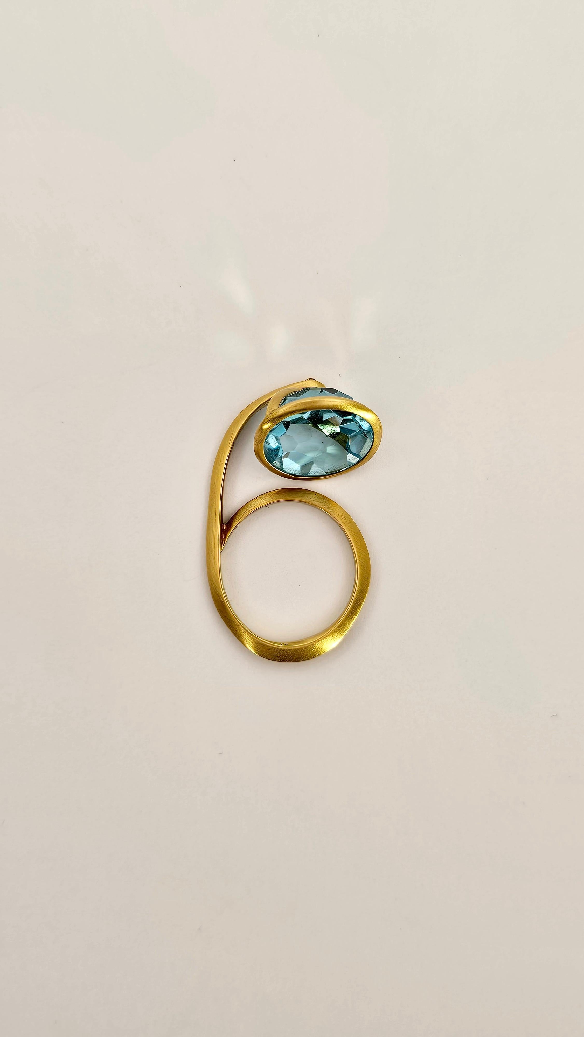 An original lantern-shaped ring design made of 18-karat yellow gold with a satin finish.
The top of the ring, which is movable and jointed, is composed of a blue Topaz with a round faceted cut and set with the pavilion part facing upward. 
This