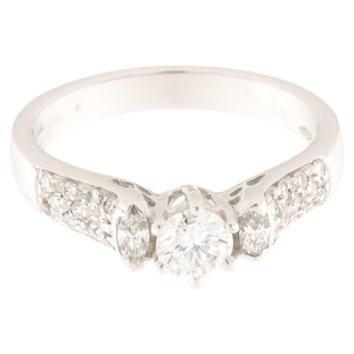 Bague solitaire en or blanc avec un diamant central de taille brillant, deux petits diamants latéraux de taille marquise et des diamants pavés. Total carat ct.0.66
