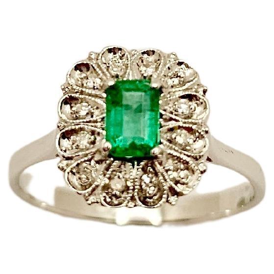 A vintage 18 kt white gold ring with Colombian Emerald of ct 0.37.
The center stone has a setting composed of 12 brilliant-cut Diamonds weighing 0.15 ct
This ring is made in Italy by master goldsmiths and every detail demonstrates its