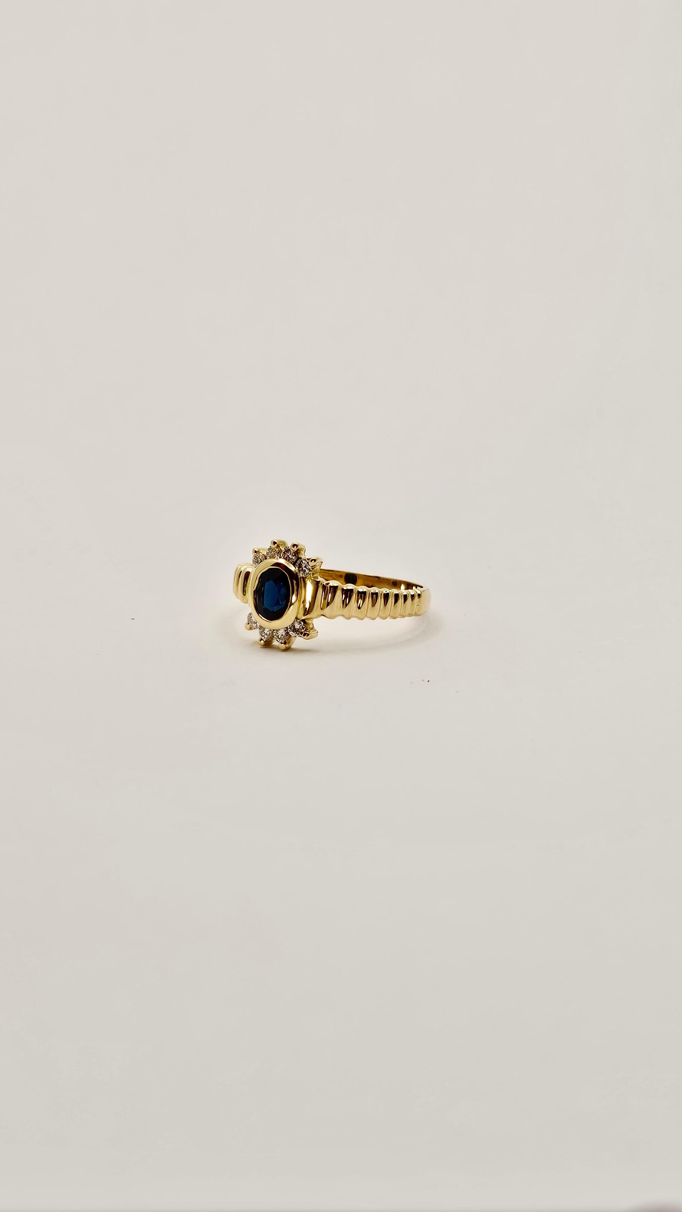 Un anello vintage di epoca 1980 circa, realizzato in oro giallo 18 Kt dal peso di 3.40 grammi.
Il castone centrale ha uno Zaffiro blu scuro intenso, di taglio ovale, la cui misura è di mm 6 x 4 circa.
Ai lati della pietra centrale vi sono