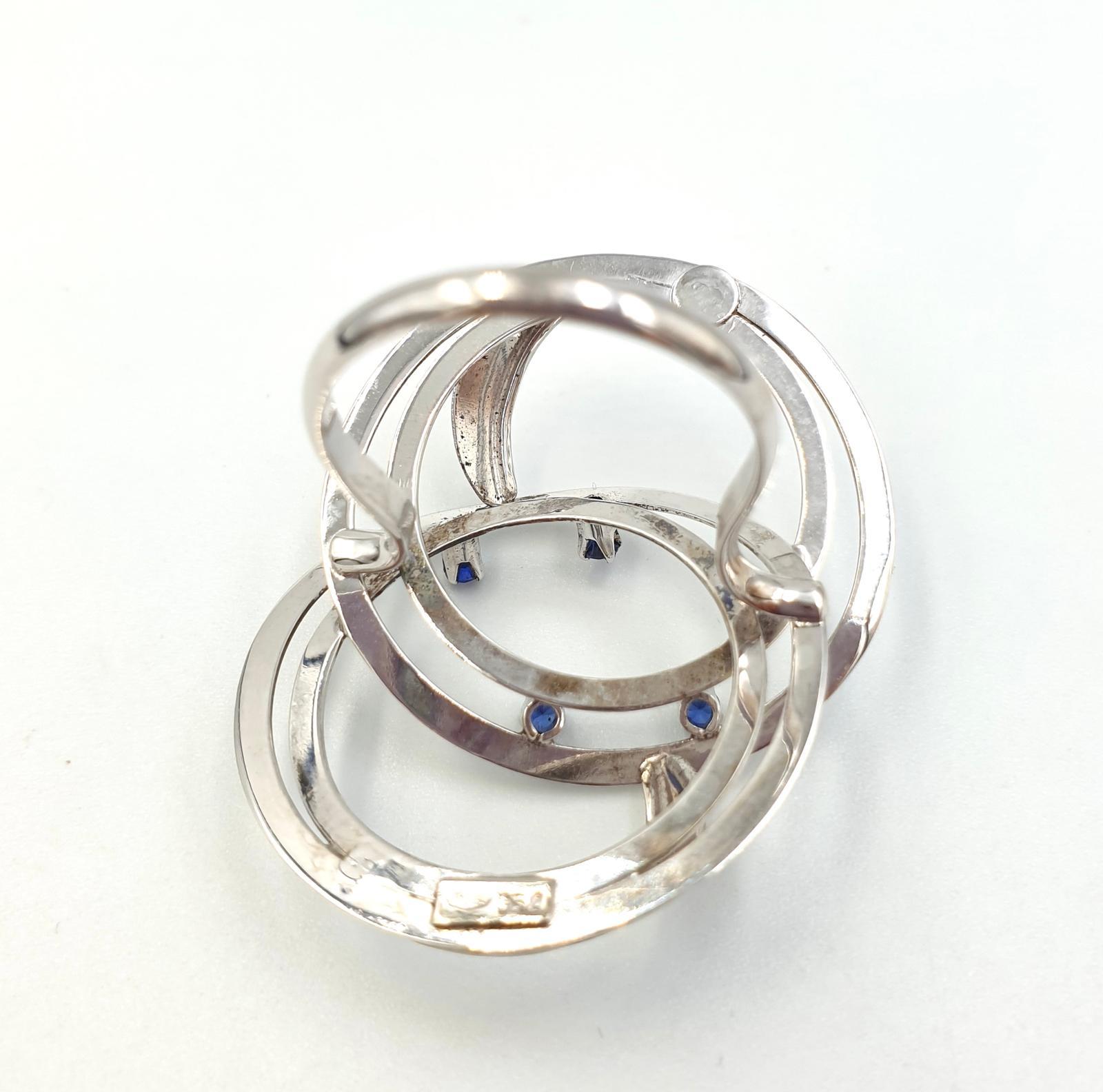 Large vintage Italian interlocking circles ring in matte and polished 18K solid white gold, professionally tested and hallmarked 750, with small synthetic sapphires.

Dimensions of the ring head 4.5 x 3.5 x 1 centimeters. Weight 6,95 grams.

Italian