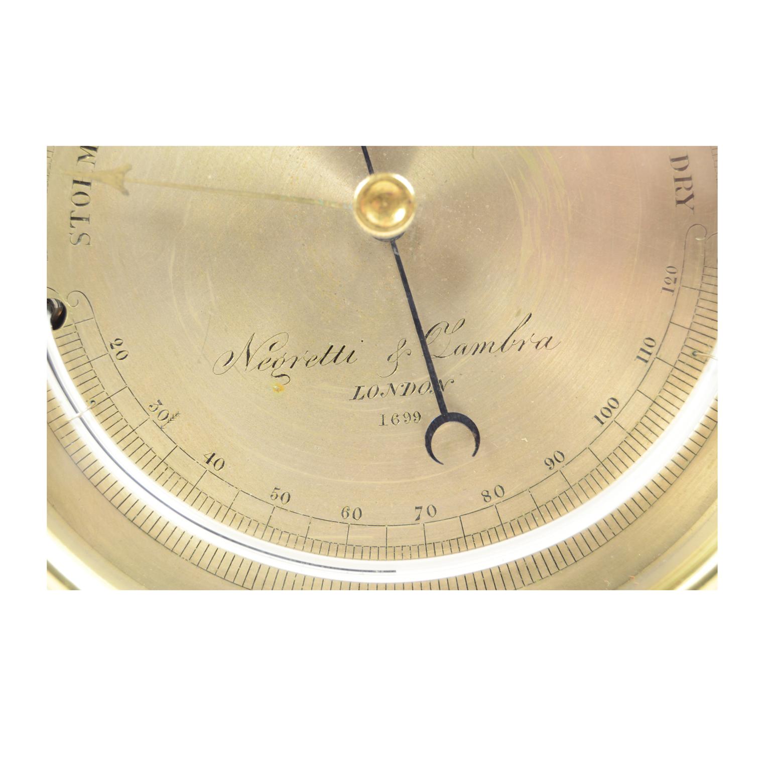 Aneroid or holosteric brass barometer made at the end of the 19th century, signed Negretti & Zambra n. I 699, complete with semicircle thermometer with engraved and silver-plated brass temperature scale calibrated from 20 ° to 120 ° degrees