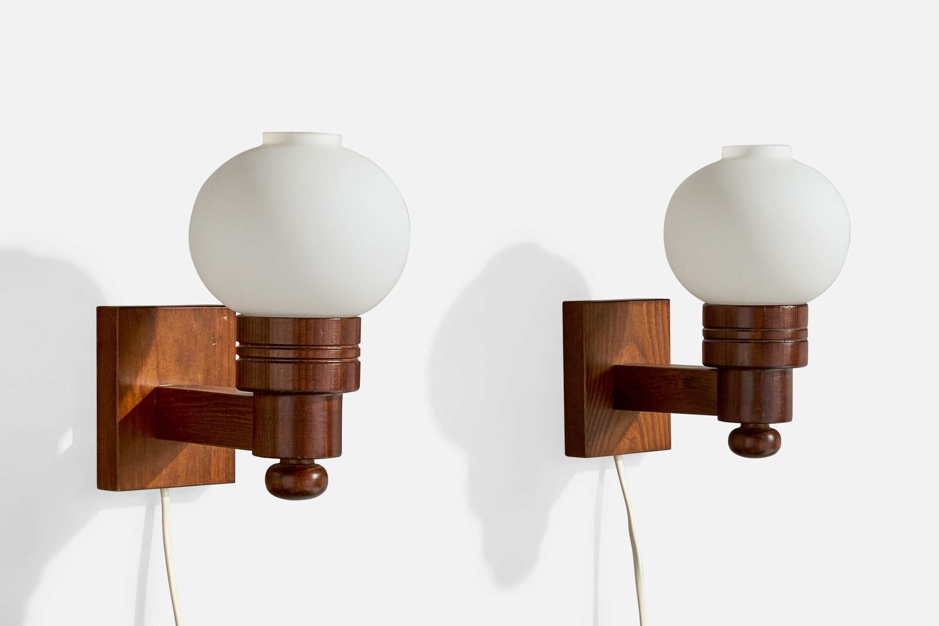 A pair of dark-stained pine and white opaline glass wall lights produced by Aneta, Sweden, c. 1970s.

Overall Dimensions (Inches): 8” H x 4.75” W x 7.75“ D

Back Plate Dimensions (Inches): 4.15” H x 3.6“ W x .875” D

Bulb Specifications: