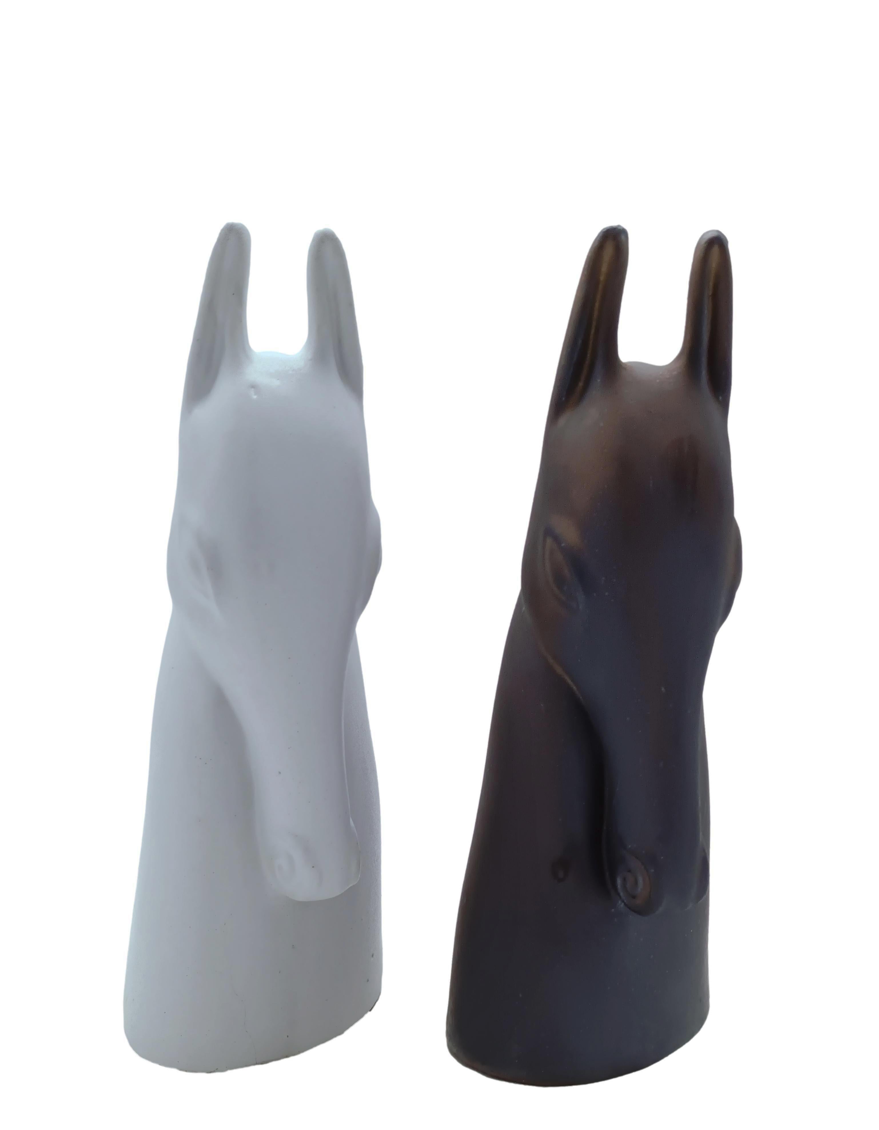 Coppia di sculture in ceramica/terriglia create dall'artista danese Anette Edmark, le sculture hanno una forma di testa di cavallo, una con smalto scuro e l'altra con smalto chiaro quasi bianco