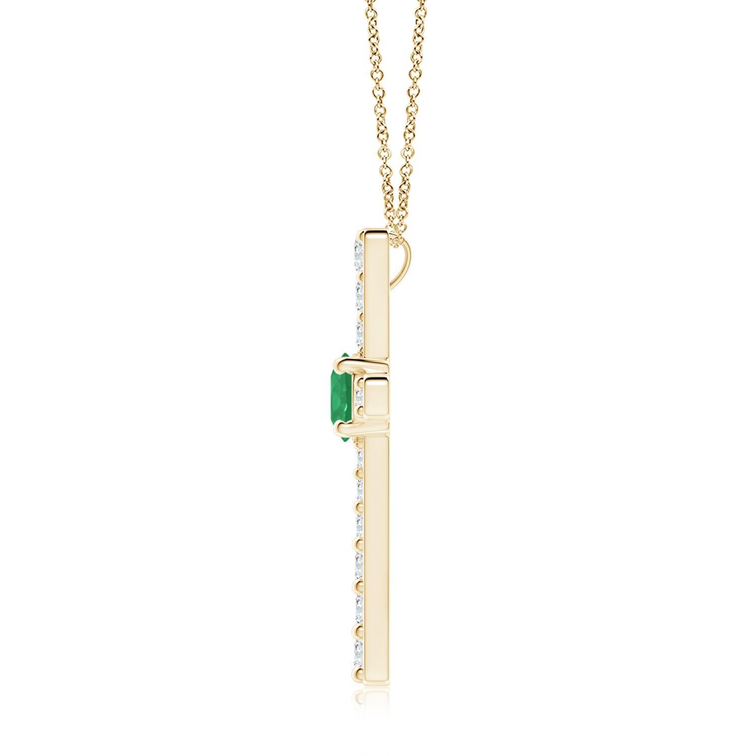 Ce pendentif en forme de croix réalisé en or jaune 14k est une splendide expression de votre foi. Elle est ornée de diamants ronds sertis sur la tranche et d'une émeraude verte luxuriante en son centre, ce qui crée un magnifique