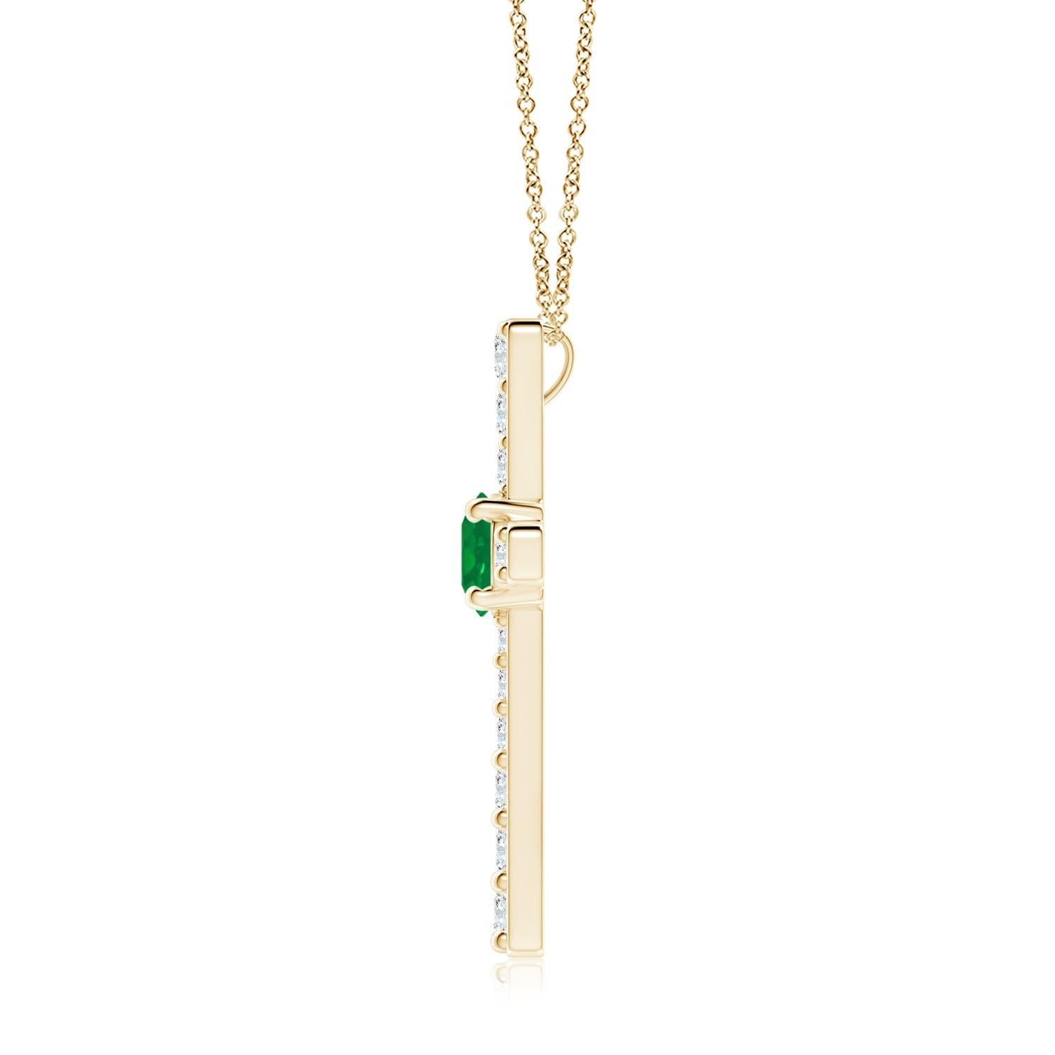 Ce pendentif en forme de croix réalisé en or jaune 14k est une splendide expression de votre foi. Elle est ornée de diamants ronds sertis sur la tranche et d'une émeraude verte luxuriante en son centre, ce qui crée un magnifique