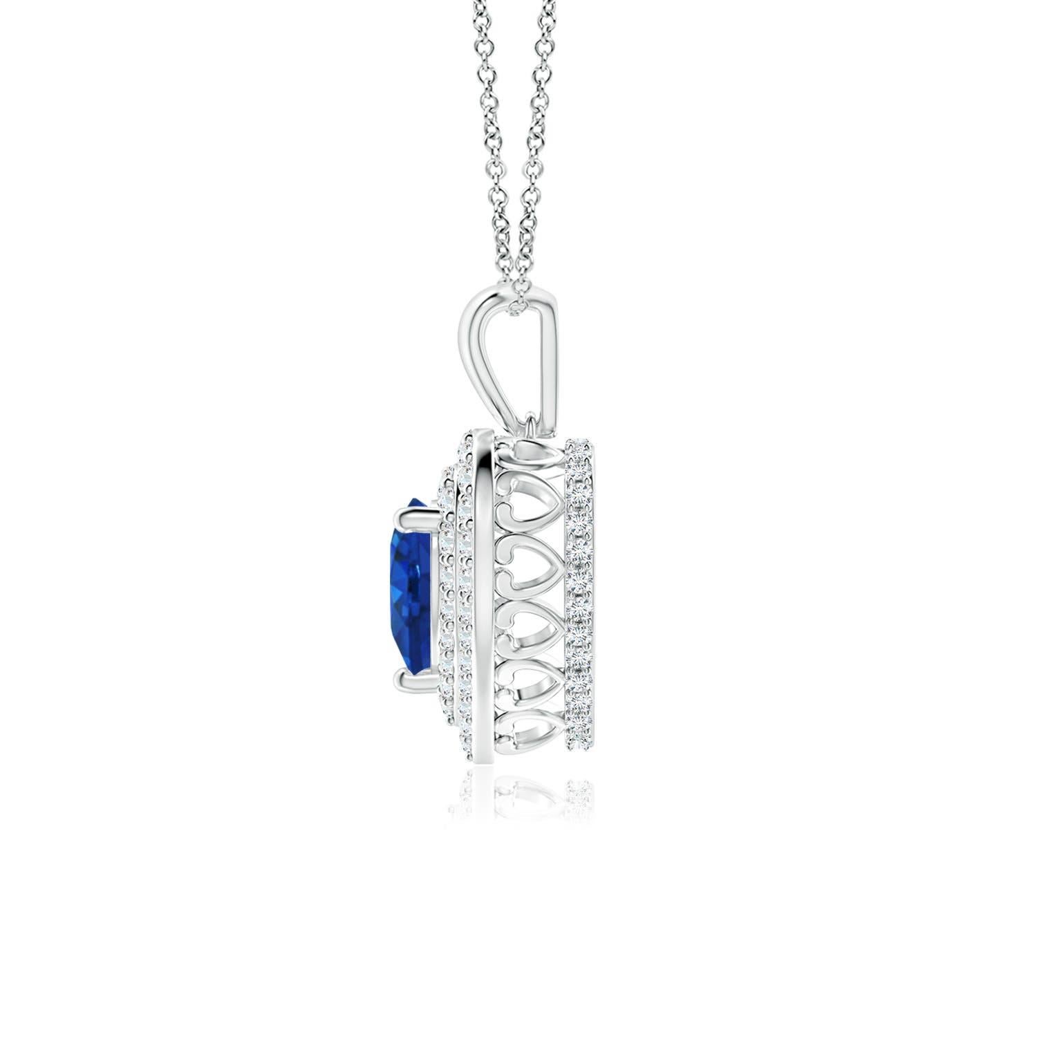 Circondato da un'aureola doppia tempestata di diamanti, uno zaffiro blu a forma di cuore è incastonato in una montatura a griffe. Un motivo a cuore tempestato di diamanti collega la balla di metallo alla cornice a cuore. I diamanti scintillanti