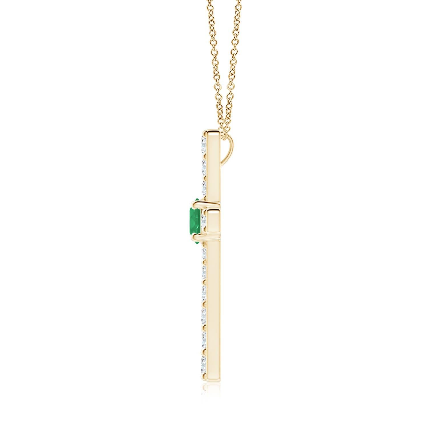 Ce pendentif en forme de croix réalisé en or jaune 14k est une splendide expression de votre foi. Elle est ornée de diamants ronds sertis sur la tranche et d'une émeraude verte luxuriante en son centre, ce qui crée un magnifique