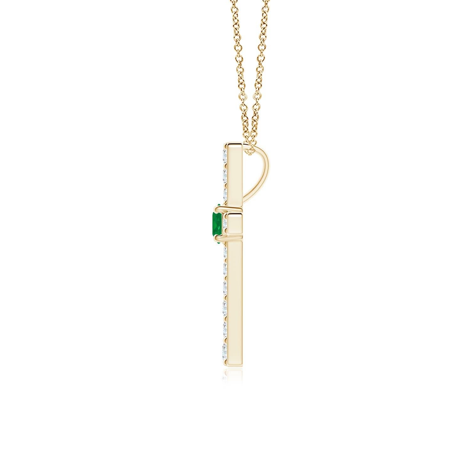 Ce pendentif en forme de croix réalisé en or jaune 14k est une splendide expression de votre foi. Elle est ornée de diamants ronds sertis sur la tranche et d'une émeraude verte luxuriante en son centre, ce qui crée un magnifique