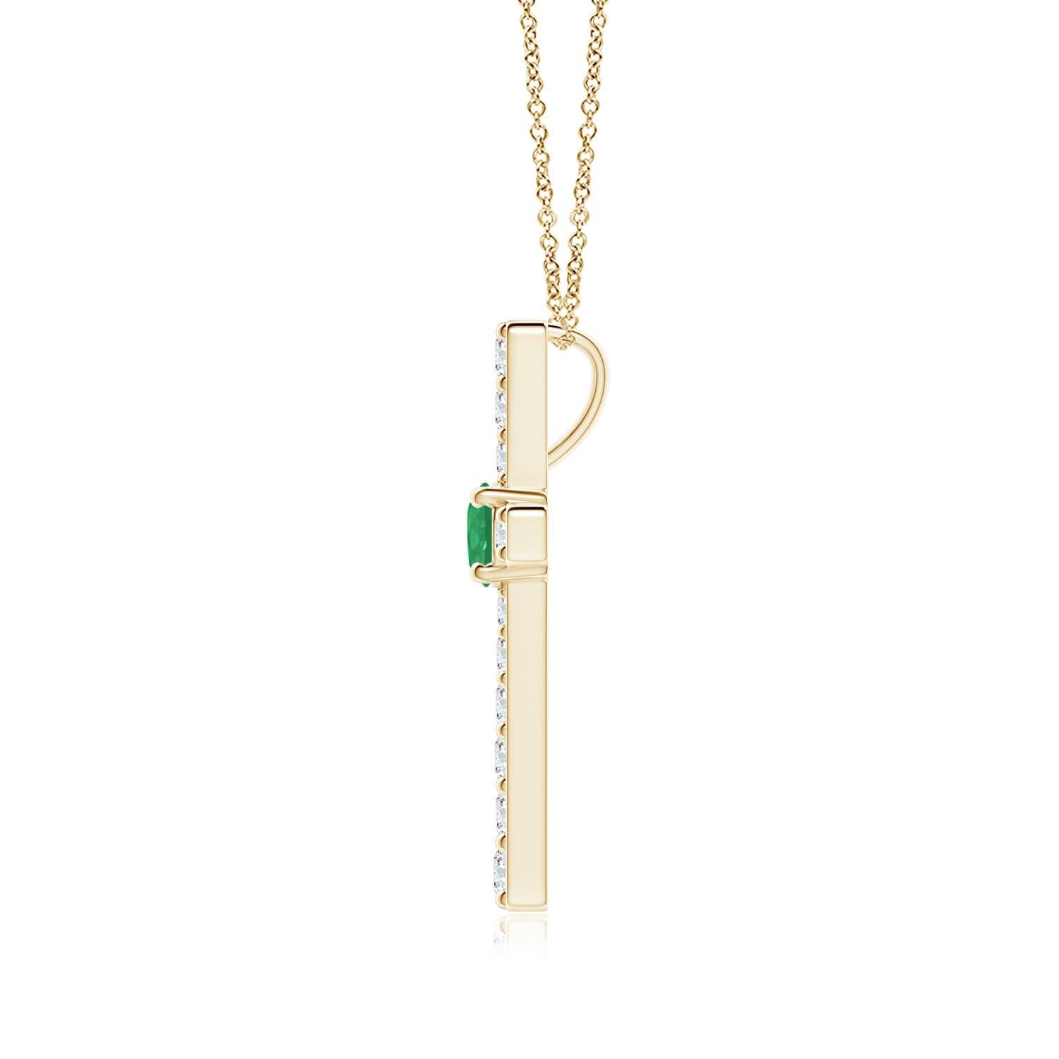 Ce pendentif en forme de croix réalisé en or jaune 14k est une splendide expression de votre foi. Elle est ornée de diamants ronds sertis sur la tranche et d'une émeraude verte luxuriante en son centre, ce qui crée un magnifique