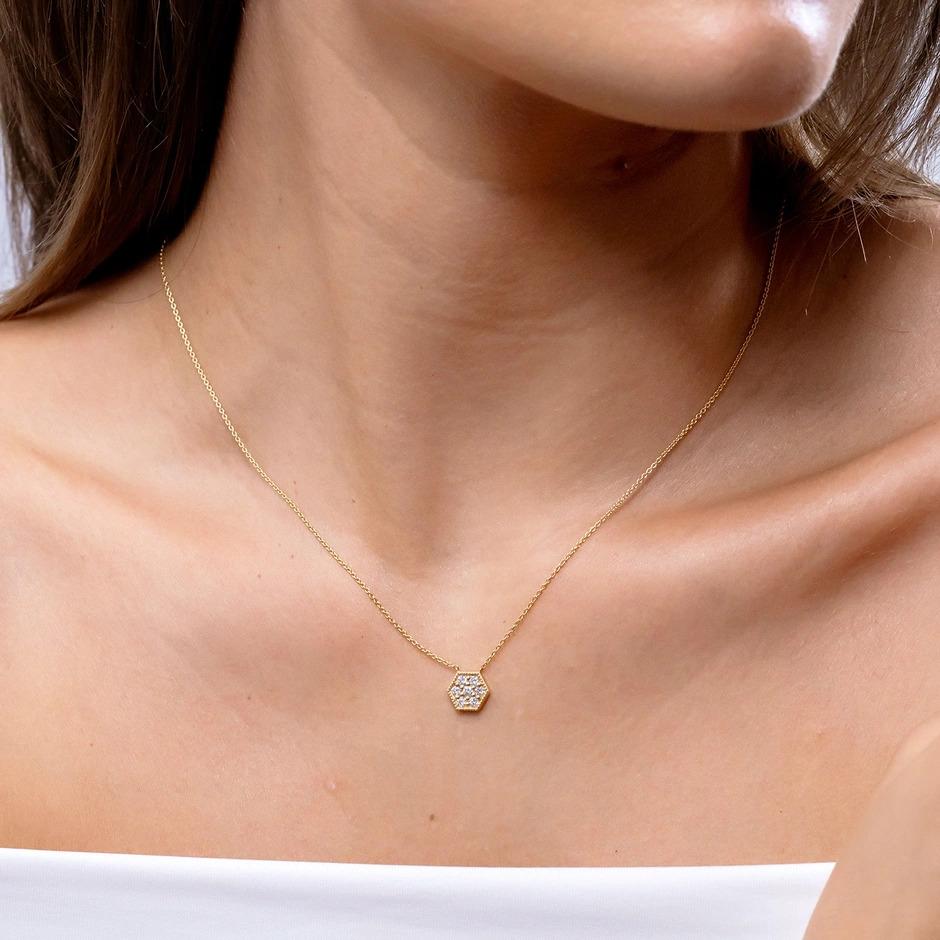Crafted in platinum, this pave diamond cluster necklace pendant fascinates with its geometric pattern. It features a hexagon shaped frame, encrusted with glimmering round diamonds. The milgrain detailing along the edges enhances the beauty of this