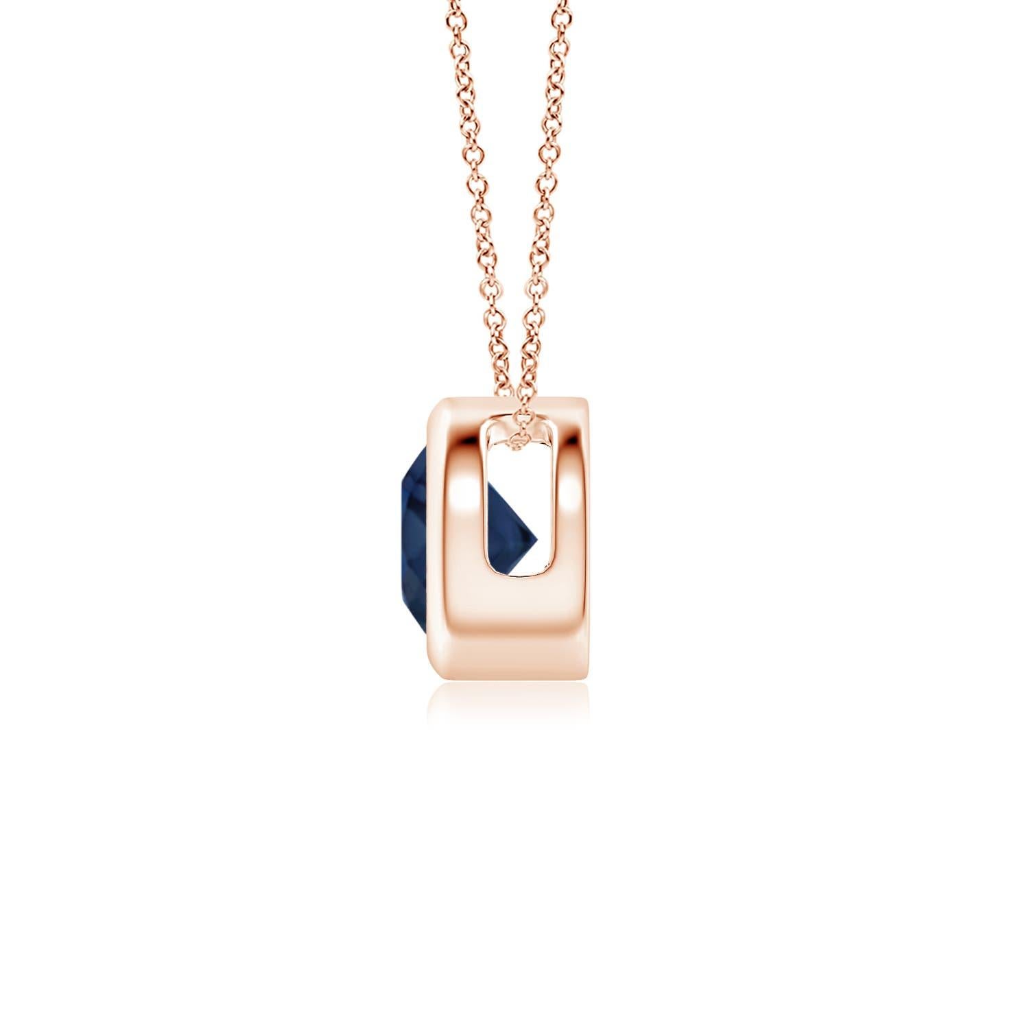 Le magnifique design de ce pendentif solitaire classique en saphir donne l'impression que la pierre centrale flotte sur la chaîne. La pierre précieuse d'un bleu éclatant est fixée dans une monture à chaton. Réalisé en or rose 14k, ce pendentif en