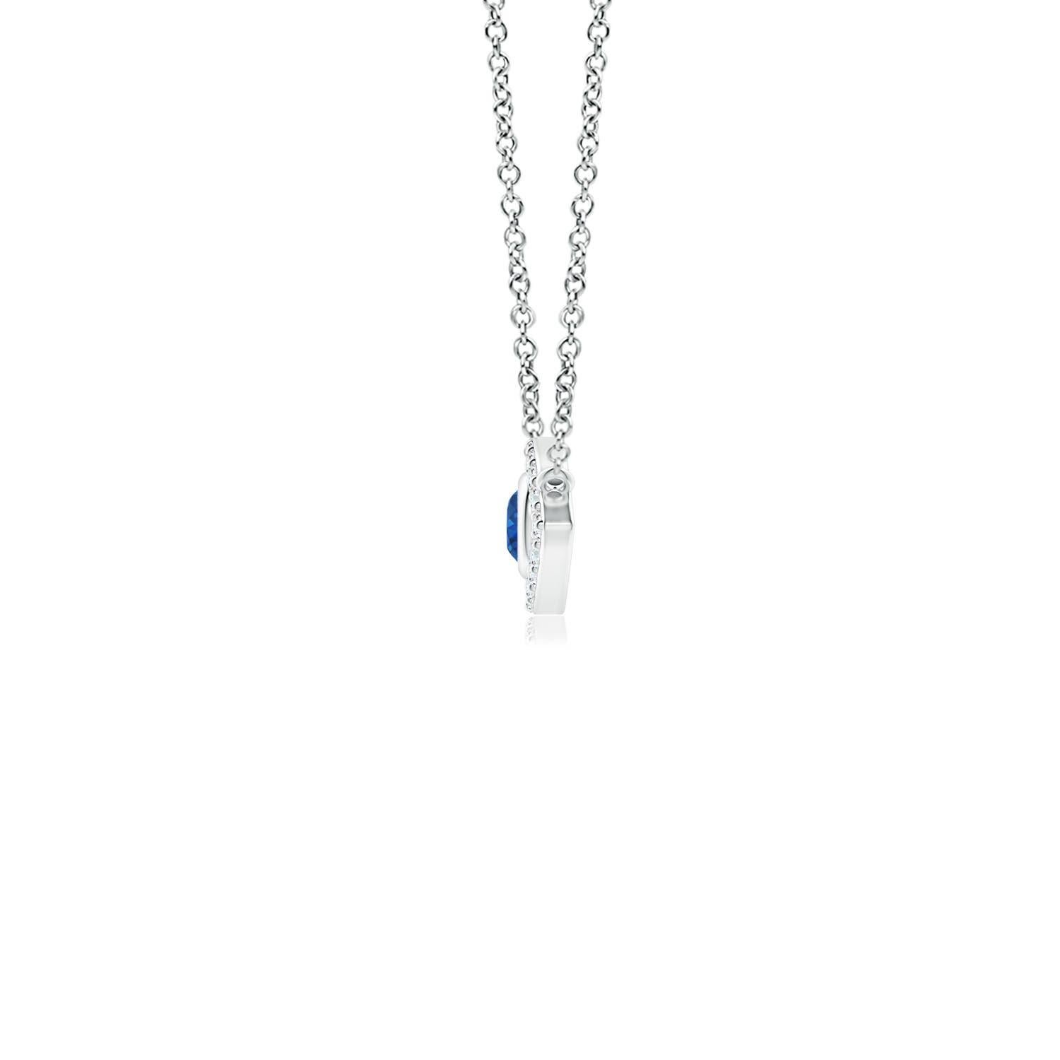 Colgando graciosamente de una paca de metal brillante hay un marco tachonado de diamantes con un zafiro redondo engastado en el centro. Los brillantes diamantes crean un contraste irresistible con el zafiro azul profundo. Elaborado en oro blanco de
