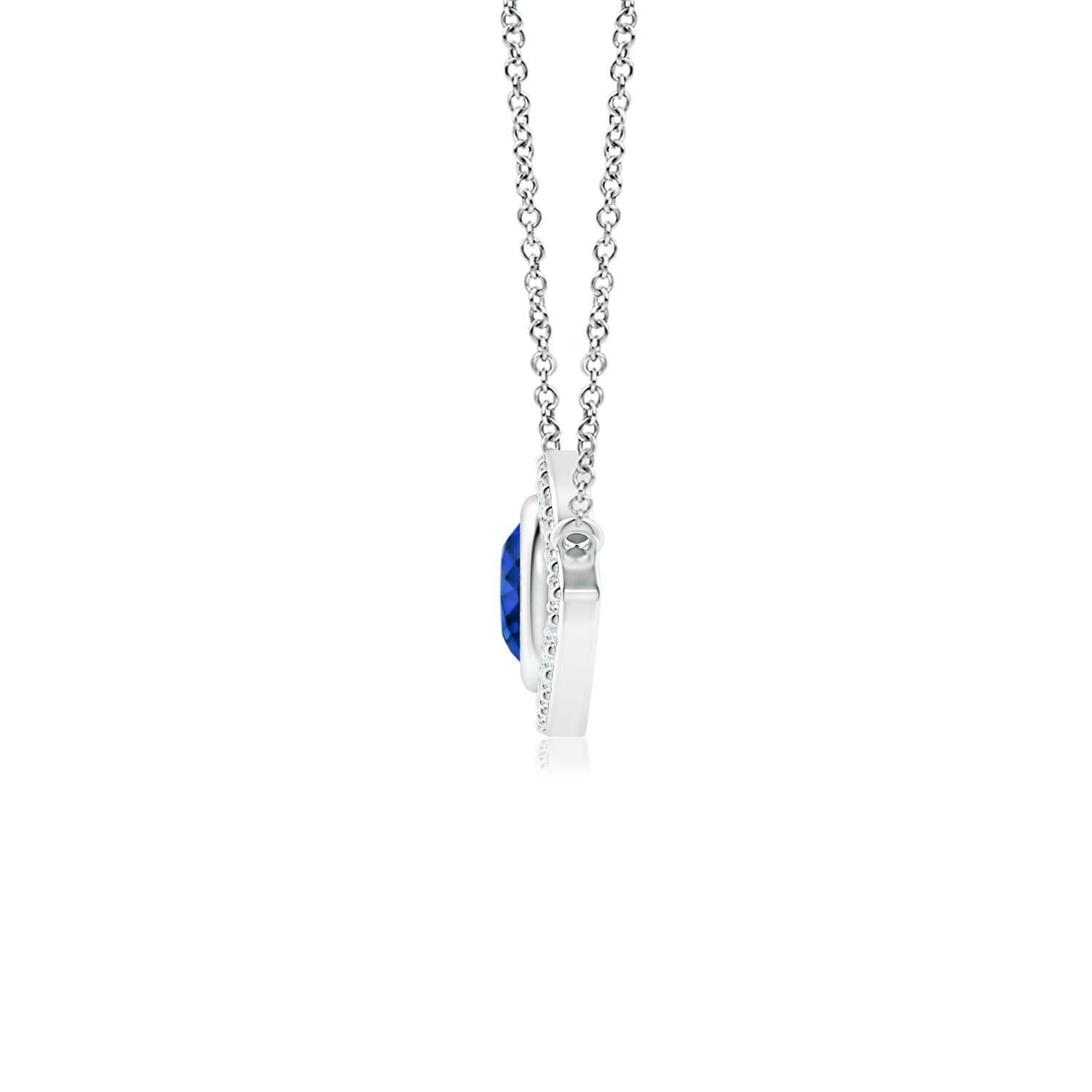 Hanging gracefully from a shiny metal bale is a diamond studded frame with a round sapphire bezel set at the center. The sparkling diamonds create a compelling contrast against the deep blue sapphire. Crafted in 14k white gold, this sapphire evil