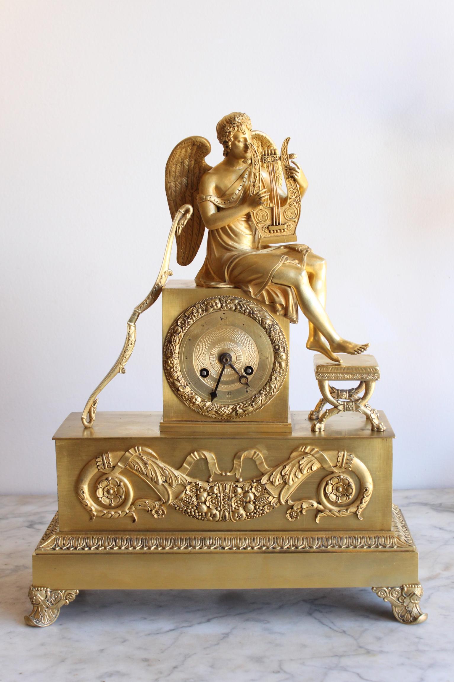 Gilt chiselled bronze clock representing an angel holding a lyre. Allegory to Love. Good condition.
Dimensions: Height 40cm, width 31cm, depth 12cm.