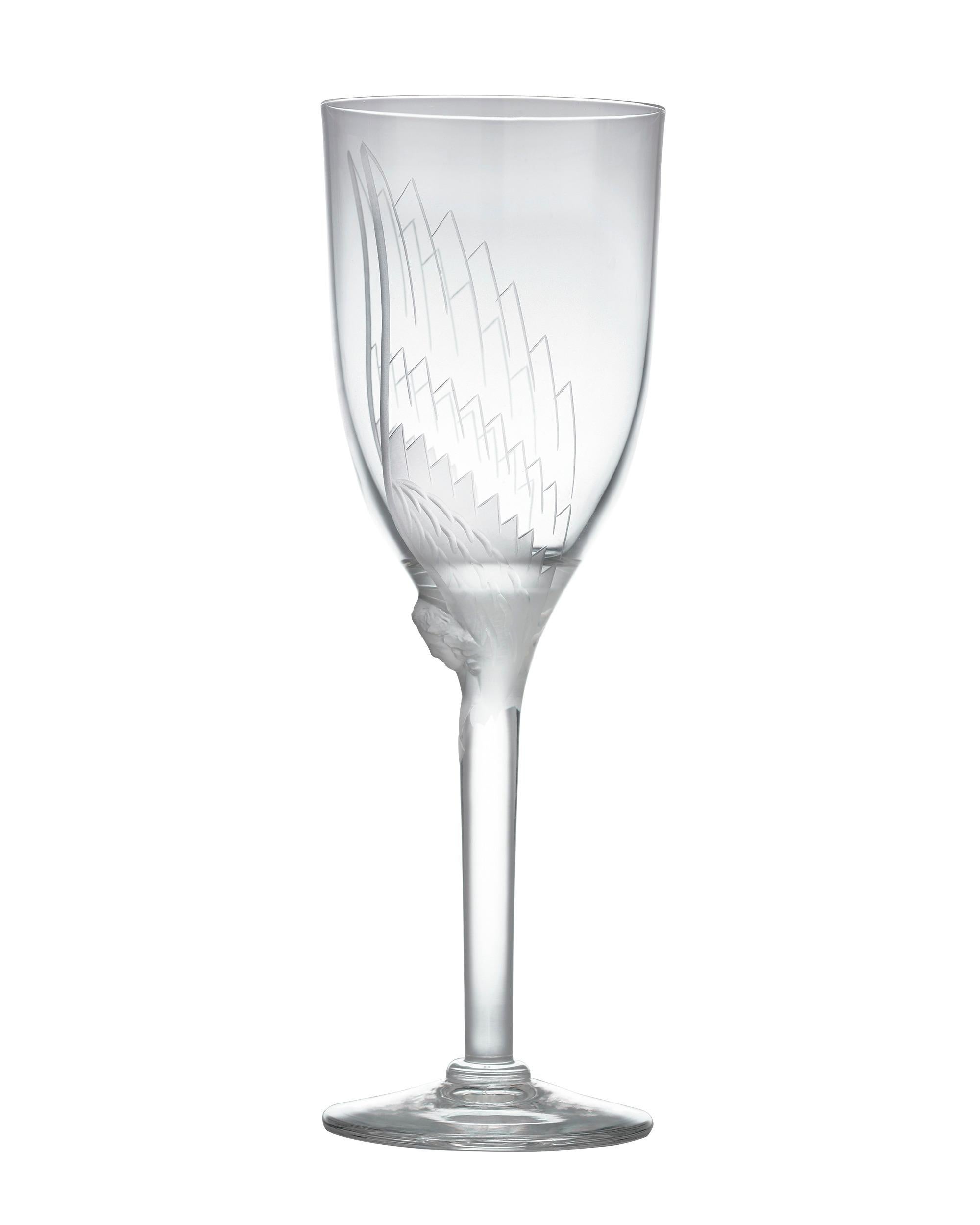 Etched angel wings gracefully envelop the flutes of these elegant crystal champagne glasses by Lalique, the iconic firm founded by the legendary glass designer René Lalique. This set of 18 glasses is crafted in the firm's Angel pattern, and a