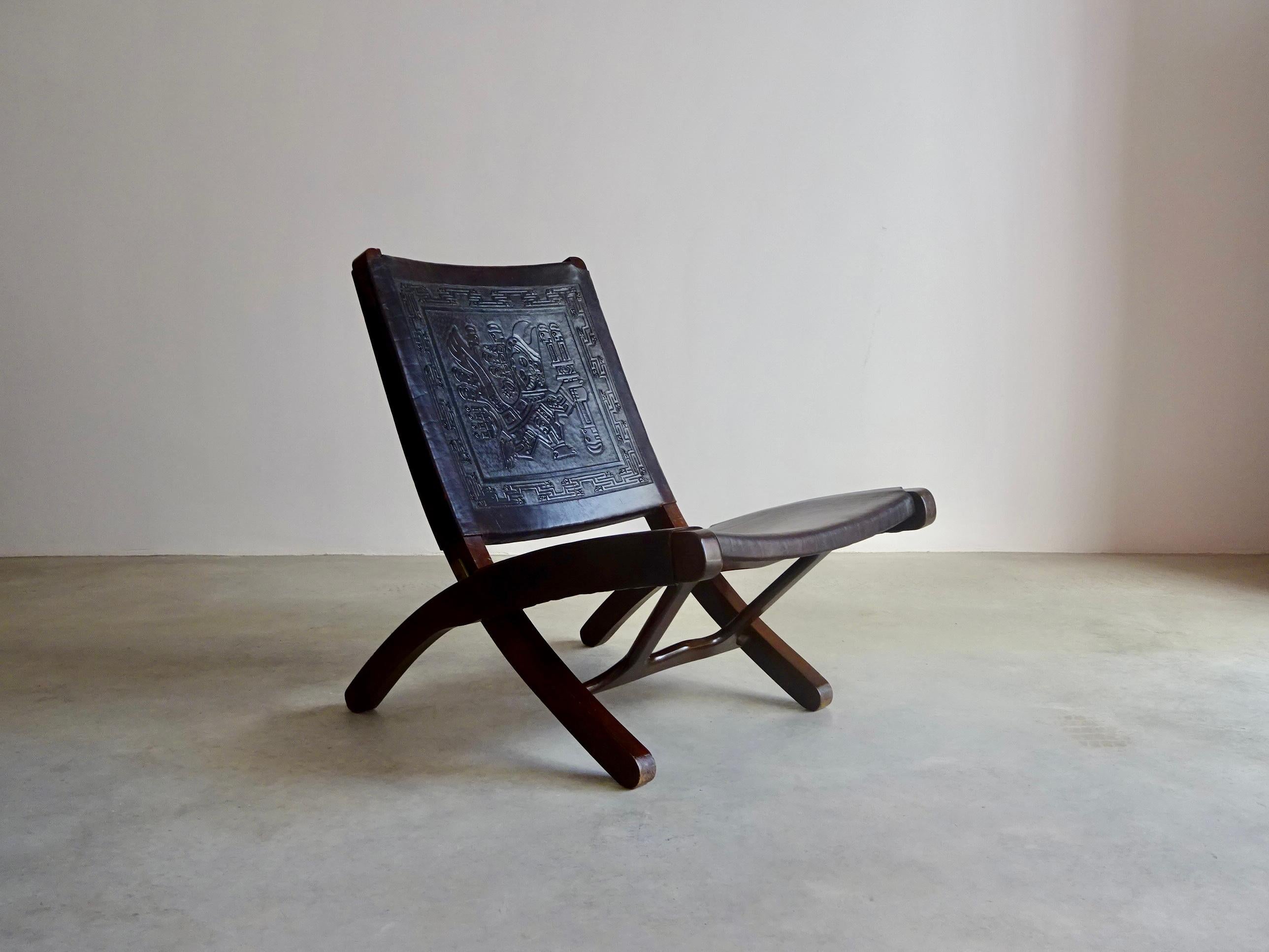 Chaise pliante conçue dans les années 60 par Ángel Pazmiño pour Muebles de Estilo (Équateur).
La structure est en bois massif de méranti et en cuir brun épais. Le cuir gaufré du dossier présente des motifs d'inspiration Pre-Columbian. Charnières en