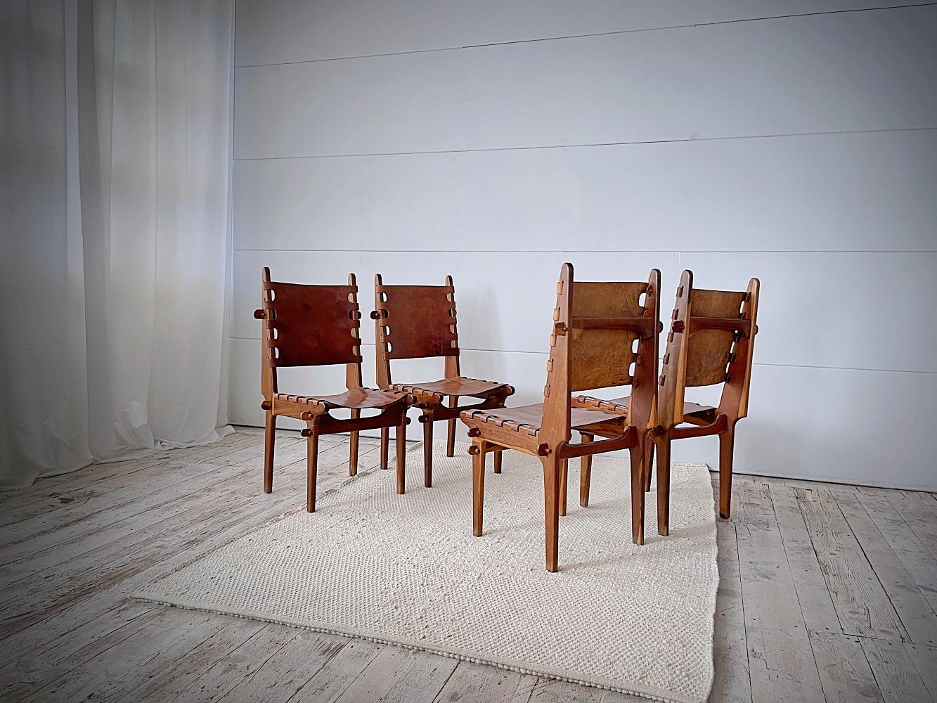 Beautiful sculptural dining chairs designed in 1960s by Angel Pazmino and manufactured by Muebles De Estilo in Ecuador. Constructed of solid rosewood & leather, using pegs and fitting together. Angel studied the designs of the Danish modernism but