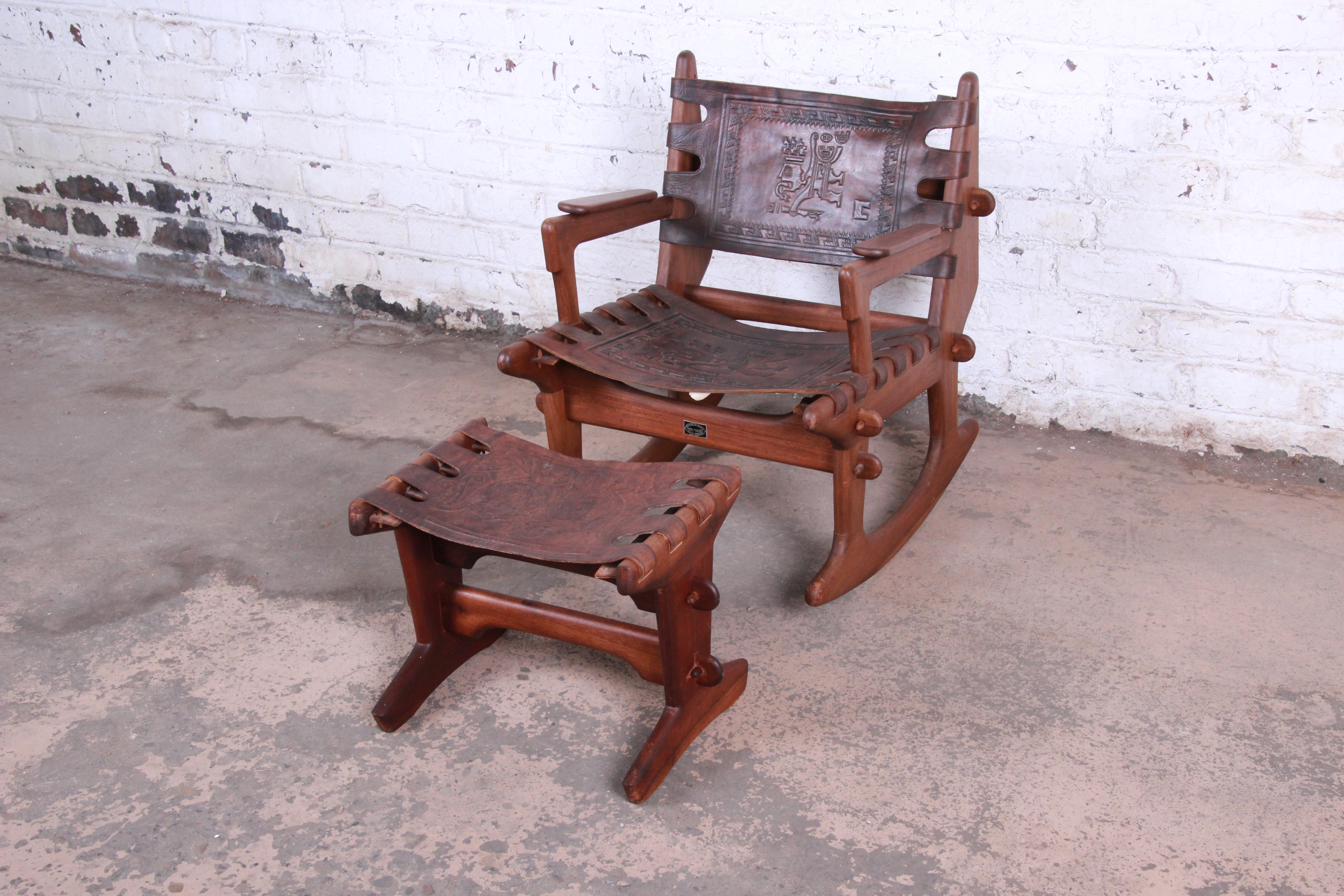 A gorgeous Ecuadorian rocking chair and ottoman by Angel Pazmino for Muebles de Estilo. The set features solid teak wood construction and original heavy cowhide leather with unique Mayan embossed designs to the seat and backrest. A quintessential