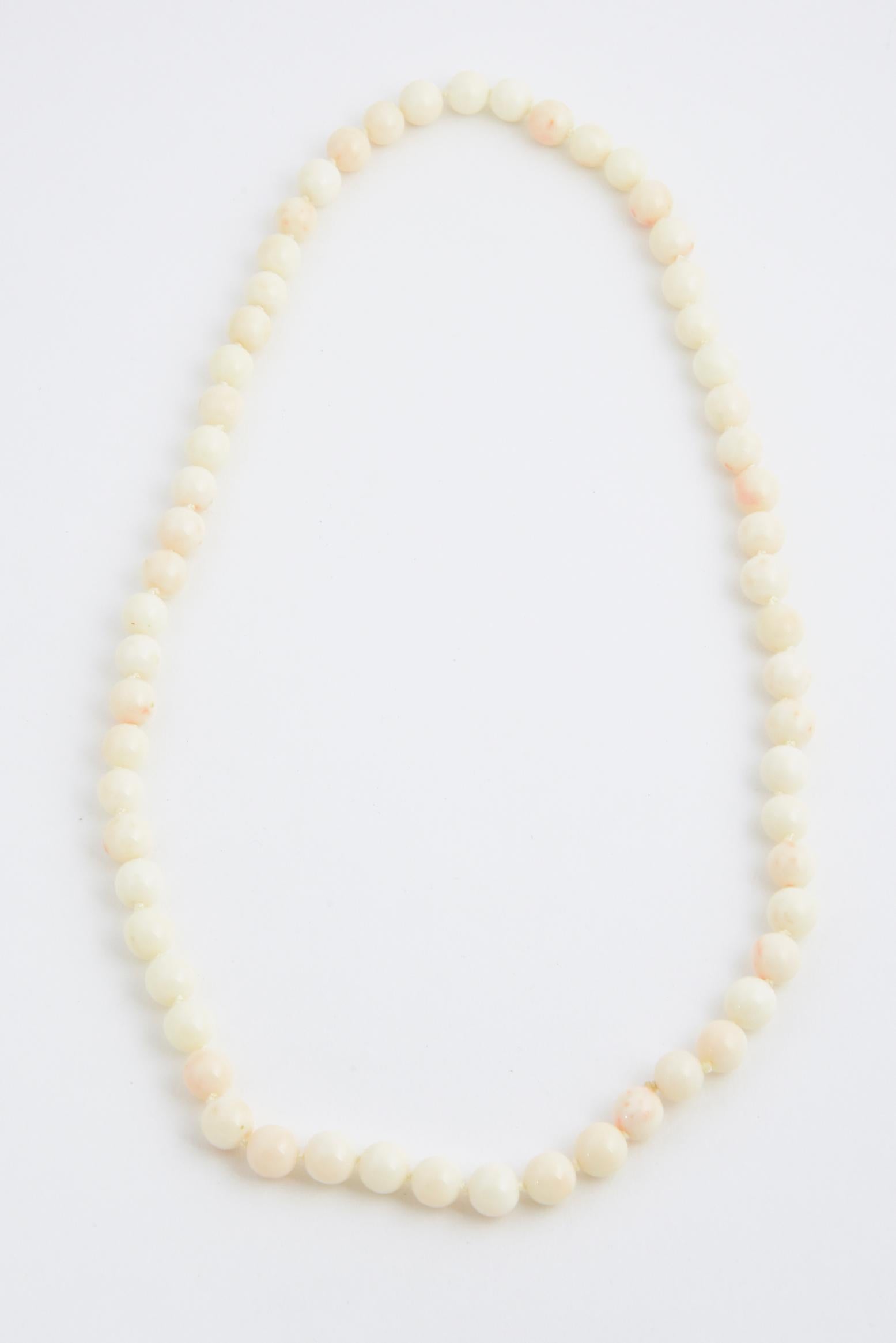 Collier de perles de corail naturel, non teinté, en peau d'ange. Les perles varient de 10 mm à 10,25 mm environ. Récemment ré-accouplé avec des noeuds entre les deux.